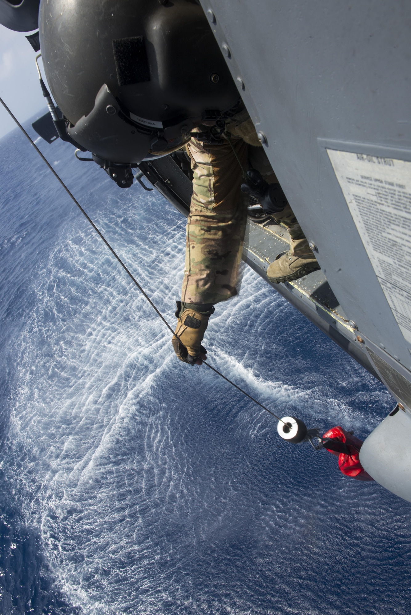 U.S. Air Force Master Sgt. Kenton Lewis, 33rd Rescue Squadron special missions aviator, simulates hoisting a casualty from the water using a winch aboard a 33rd RQS HH-60G Pave Hawk helicopter during a large force exercise near Okinawa, Japan, June 30, 2015. The exercise, which integrated U.S. Air Force and Marine Corps assets on Okinawa, was designed to allow the units to practice air-to-air capabilities while supporting ground troops. (U.S. Air Force photo by Staff Sgt. Maeson L. Elleman/Released)