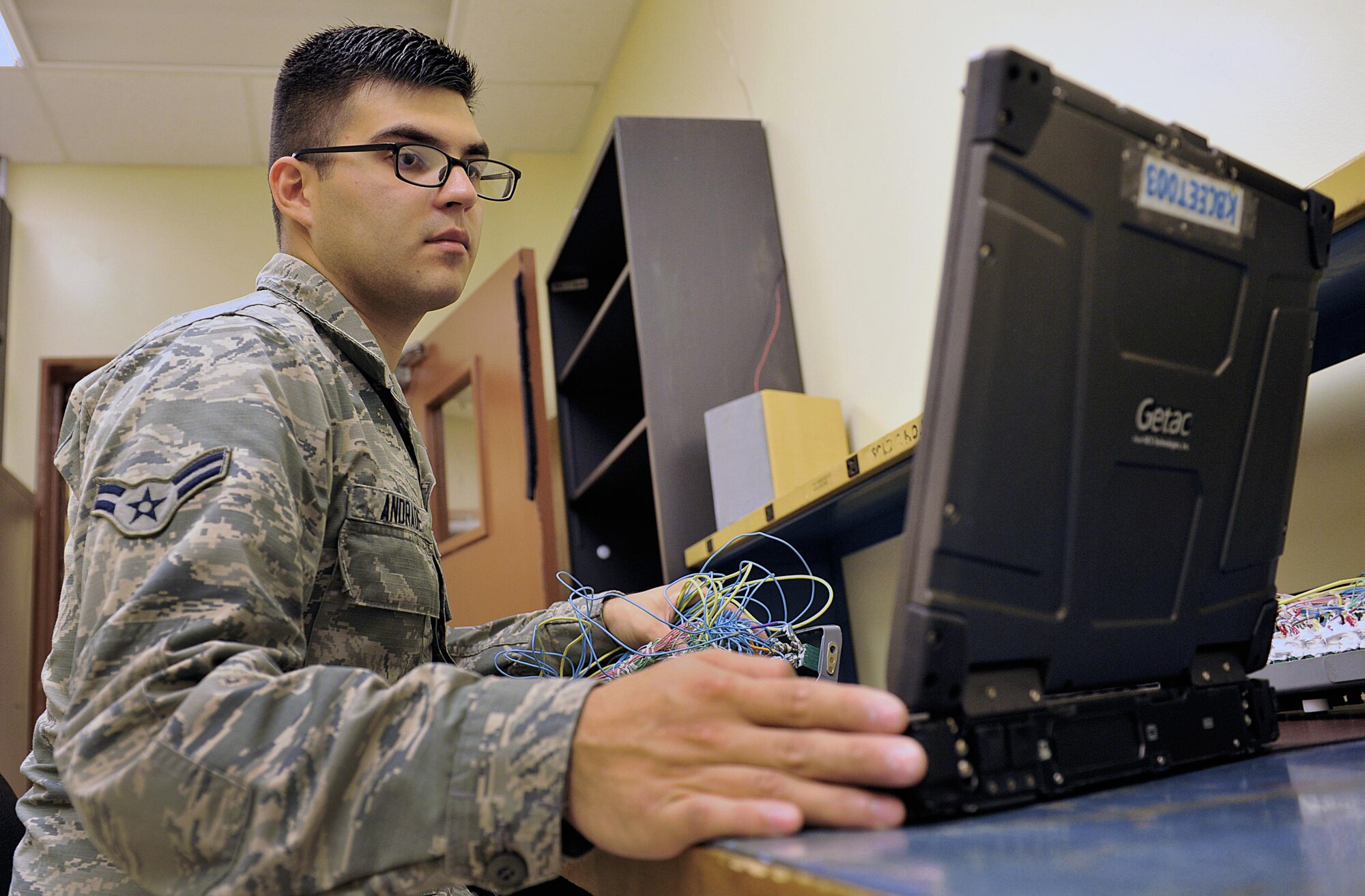 U.S. Air Force Airman 1st Class Luis Andrade, 18th Component Maintenance Squadron electrical and environmental journeyman, reviews an electronic technical order before re-wiring an F-15C Eagle essential bus circuit breaker panel on Kadena Air Base, Japan, June 25, 2015. The panel interrupts the flow of electricity to prevent a system or component failure downstream of the circuit breaker. (U.S. Air Force photo by Naoto Anazawa/Released)