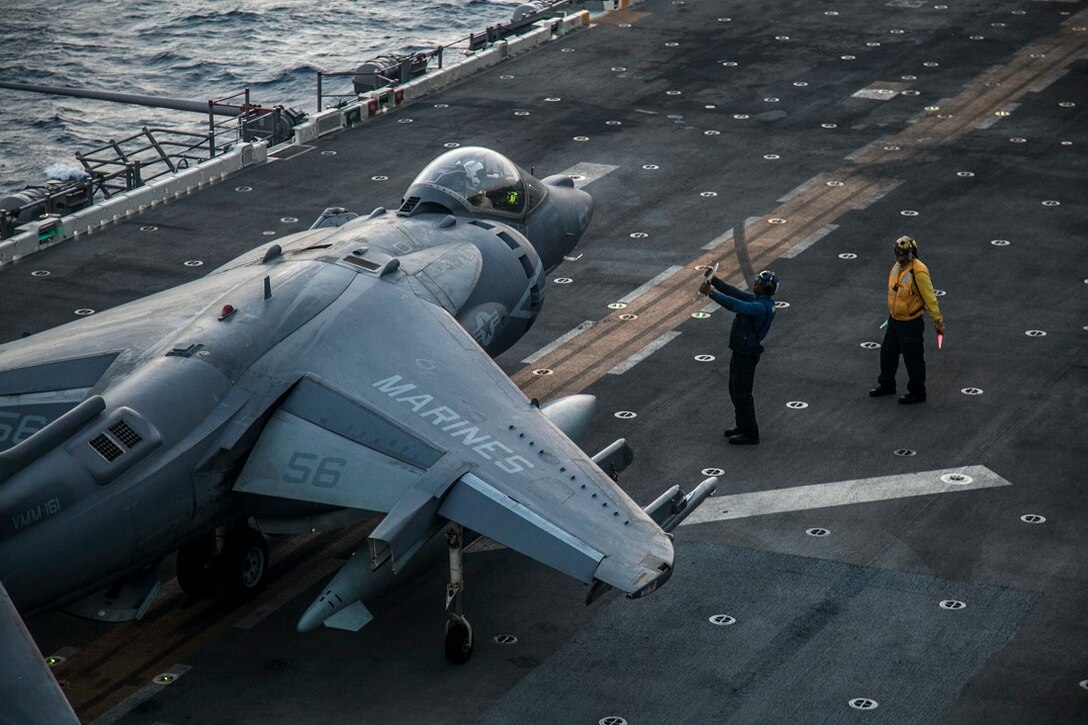 GULF OF ADEN (June 28, 2015) An AV-8B Harrier from the “Greyhawks” of Marine Medium Tiltrotor Squadron 161 (Reinforced), 15th Marine Expeditionary Unit, is given final instruction by U.S. Sailors with the USS Essex Amphibious Ready Group on the flight deck of the amphibious assault ship USS Essex (LHD 2). The pilots maintain their flight readiness by performing take-off and landing drills. The 15th MEU is embarked on the Essex Amphibious Ready Group and deployed to maintain regional security in the U.S. 5th Fleet area of operations. (U.S. Marine Corps photo by Cpl. Elize McKelvey/Released)