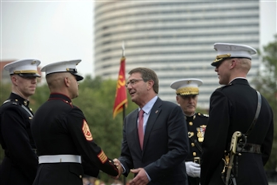 Defense Secretary Ash Carter thanks Marines after the Marine Corps Sunset Parade at the U.S. Marine Corps War Memorial in Arlington, Va., June 30, 2015. Carter was the parade's guest of honor.