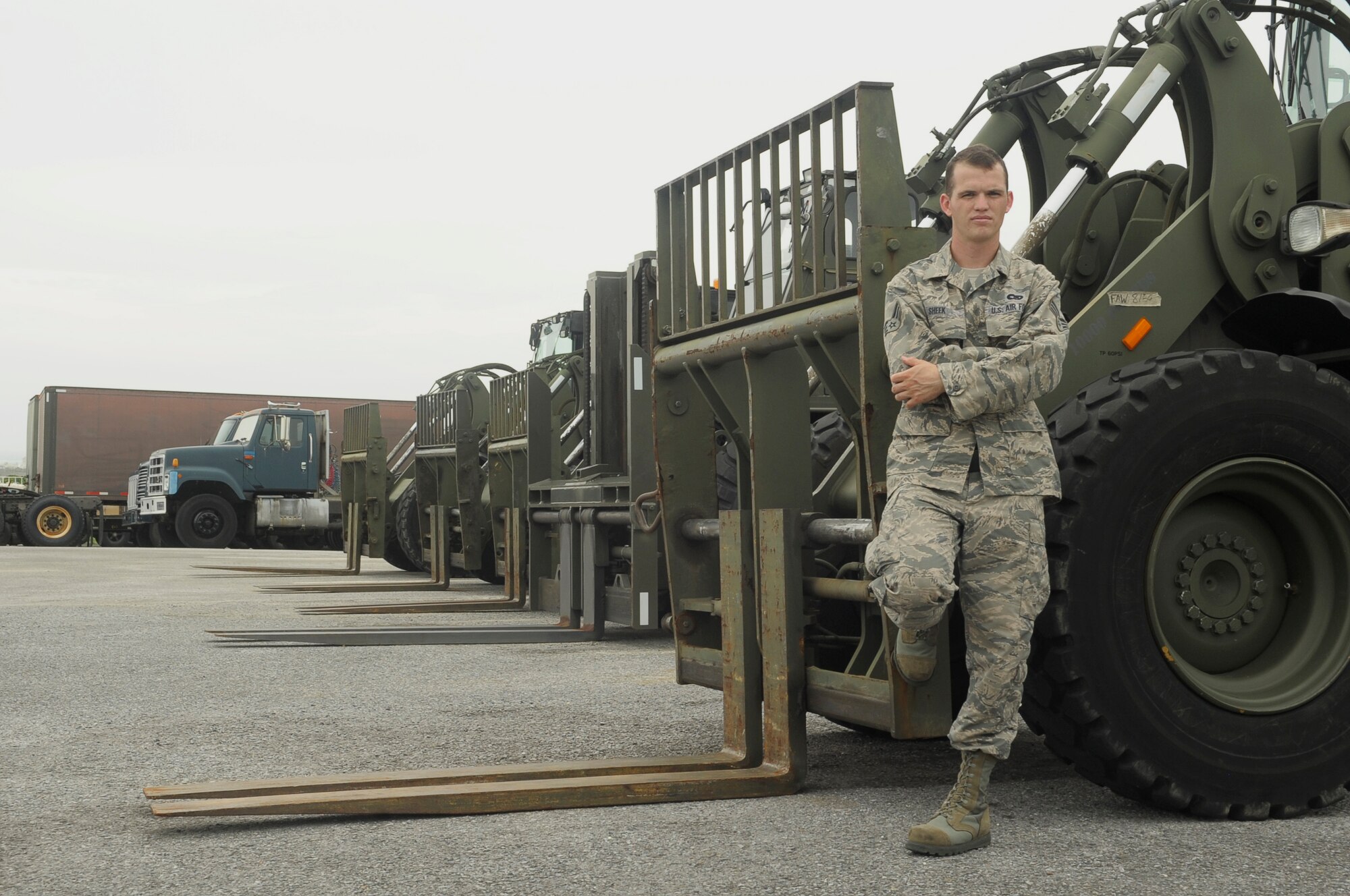 U.S. Air Force Senior Airman Chance Sheek, 18th Logistics Readiness Squadron vehicle operations vehicle operator, stands next to forklifts he works with every day on Kadena Air Base, Japan, June 29, 2015. During the week, Sheek does anything from driving around distinguished visitors to loading trucks, but as a member of the Civil Air Patrol, he leads cadets through search and rescue exercises and teaches them skills like using  compasses, land navigation, radio usage and basic medical skills (U.S. Air Force photo by Airman 1st Class Zackary A. Henry)