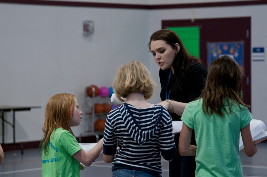 Jessica Foley, Missoula Children’s Theatre Tour actor and director, teaches children from F.E. Warren Air Force Base, Wyo. their lines during rehearsals for the group’s play, “King Arthur’s Quest,” June 23. 2015. This is Foley’s first time on a military base and she said she was surprised by the teamwork displayed by the children. (U.S. Air Force photo by Airman 1st Class Malcolm Mayfield)