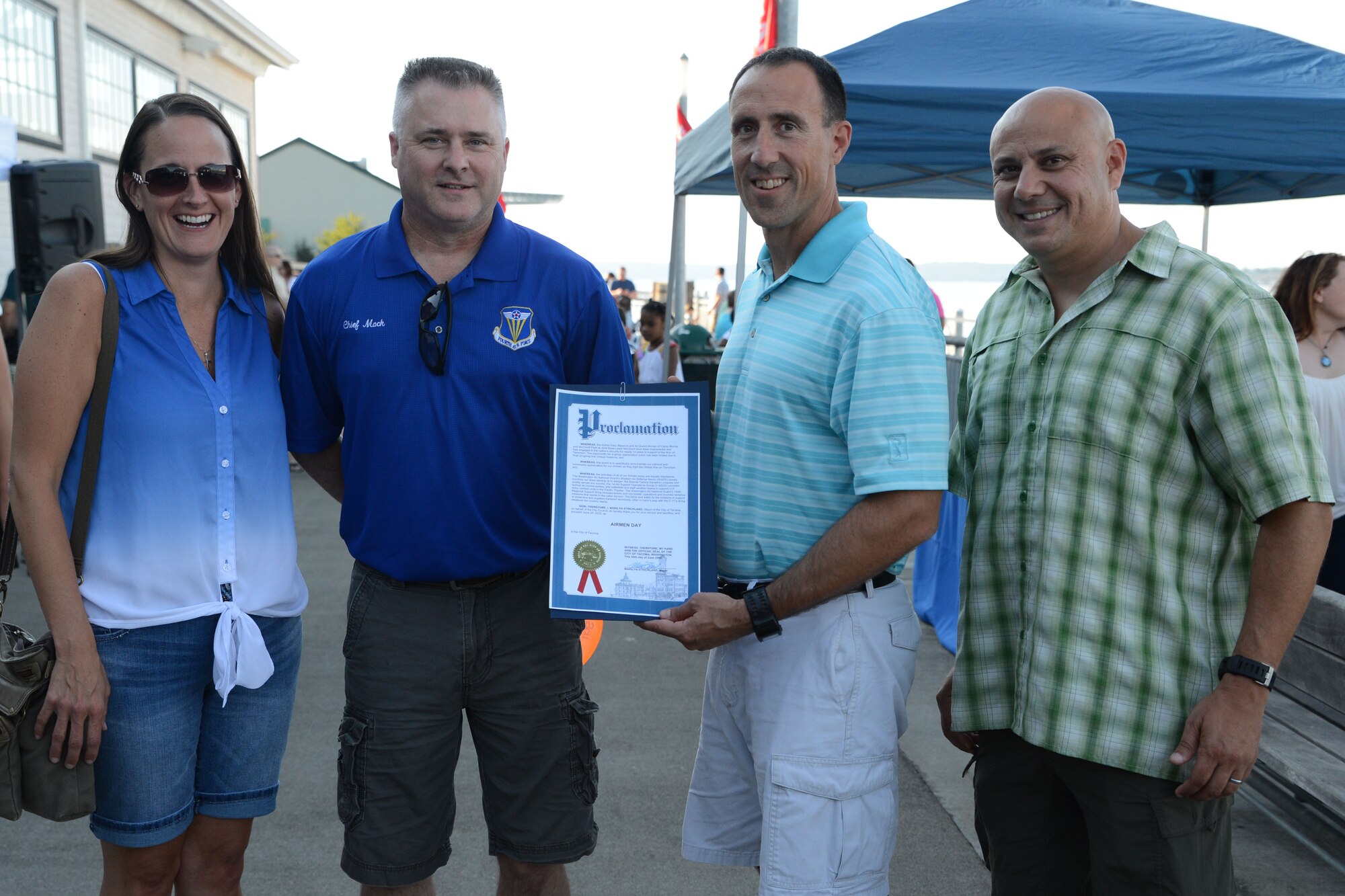 (From left to right) Chief Master Sgt. Trisha Almond, Washington Air National Guard command chief, Chief Master Sgt. Anthony Mack, 446th Airlift Wing command chief, Col. Leonard Kosinski, 62nd Airlift Wing commander, and Chief Master Sergeant Tico Mazid, 62nd Airlift Wing command chief, pose for a photo with the Airman Day proclamation, June 29, 2015, in Tacoma, Wash. The proclamation, signed by Marilyn Strickland, the Mayor of Tacoma, declared June 29 as Airmen Day in Tacoma. Airman Appreciation Day is hosted by the Air Force Association and is sponsored by several Joint Base Lewis-McChord community partners. (U.S. Air Force photo\Staff Sgt. Katie Jackson)