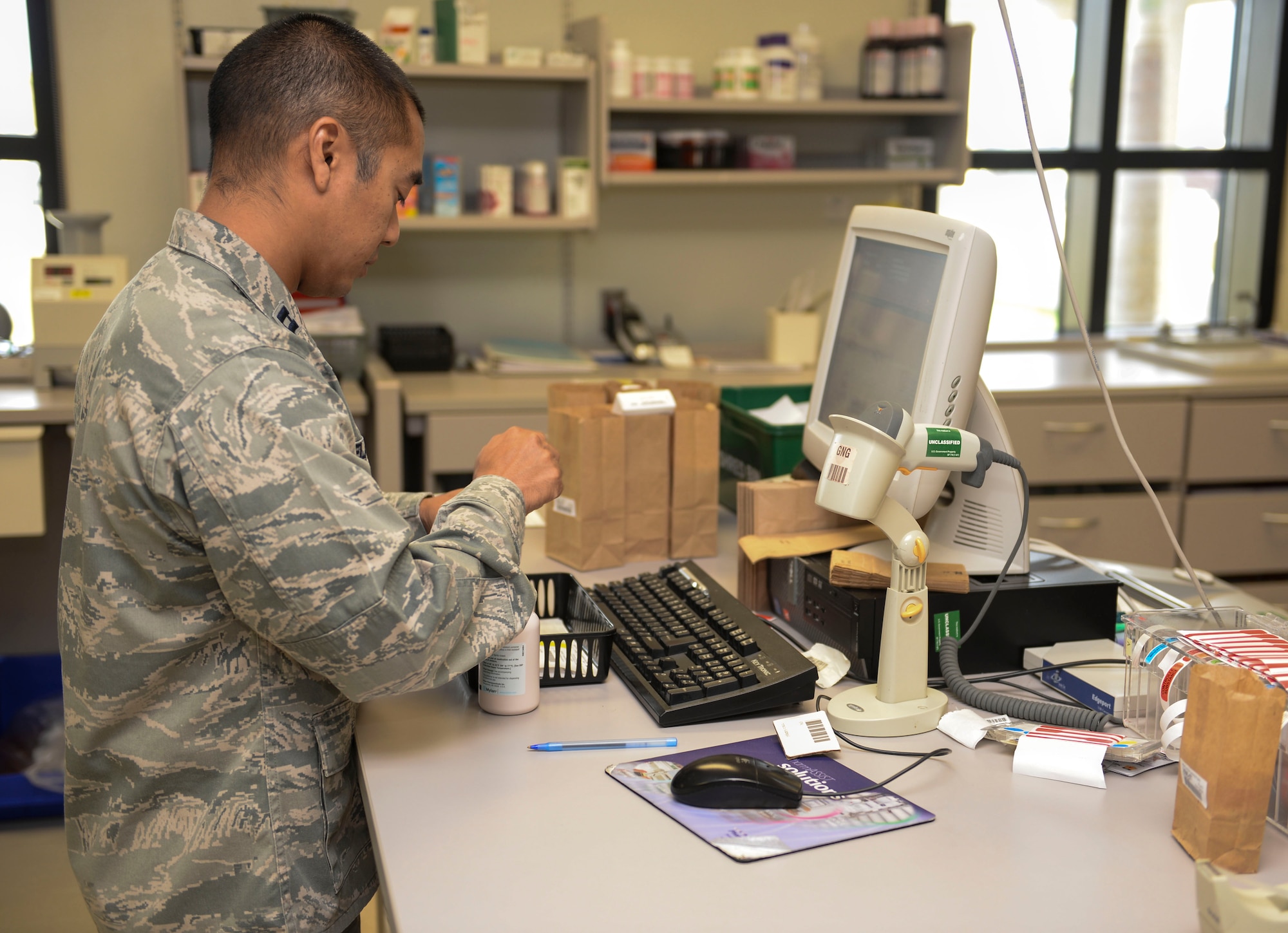 Capt. Ronald Elazegui, 36th Medical Support Squadron pharmacist, prepares prescriptions for Team Andersen members July 1, 2015, at Andersen Air Force Base, Guam. On average, the pharmacy fills and dispenses 150 prescriptions a day. (U.S. Air Force photo by Airman 1st Class Joshua Smoot/Released)