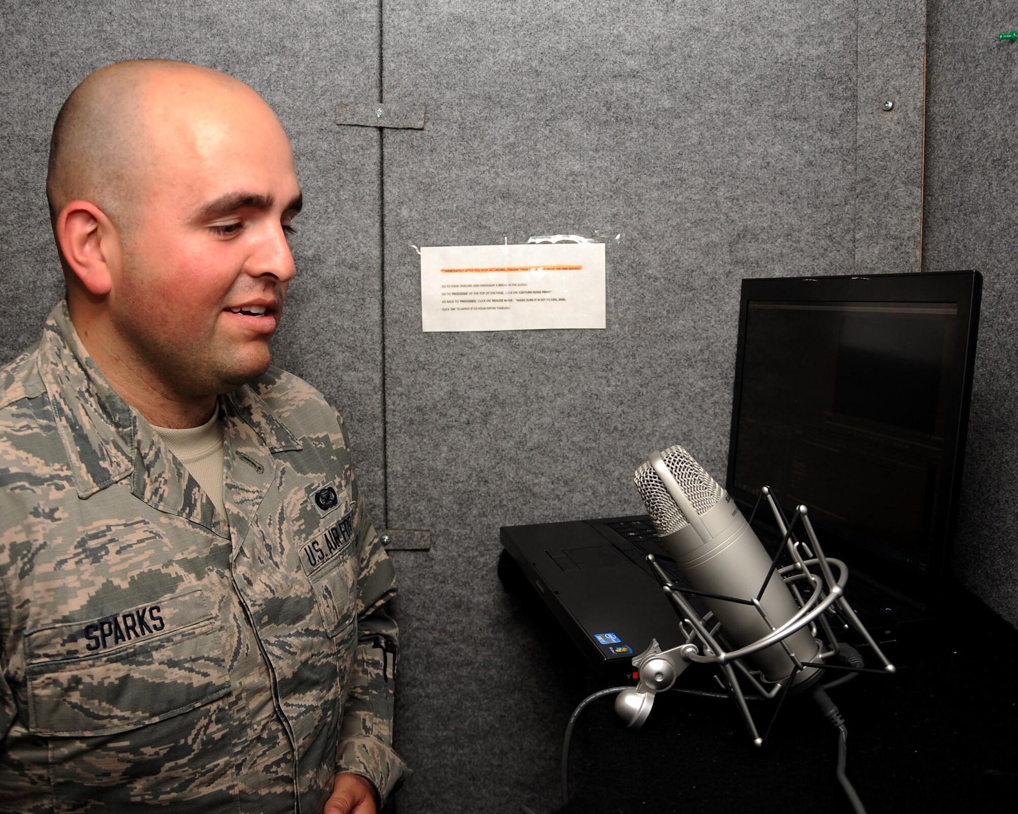 Airman 1st Class Ryan Sparks, 319th Air Base Wing Public Affairs photojournalist, practices singing the national anthem in the PA studio booth on Grand Forks Air Force Base, N.D. on July 1, 2015. Sparks was named warrior of the week for the first week of July. (U.S. Air Force Photo by Senior Airman Zachiah Roberson/released)