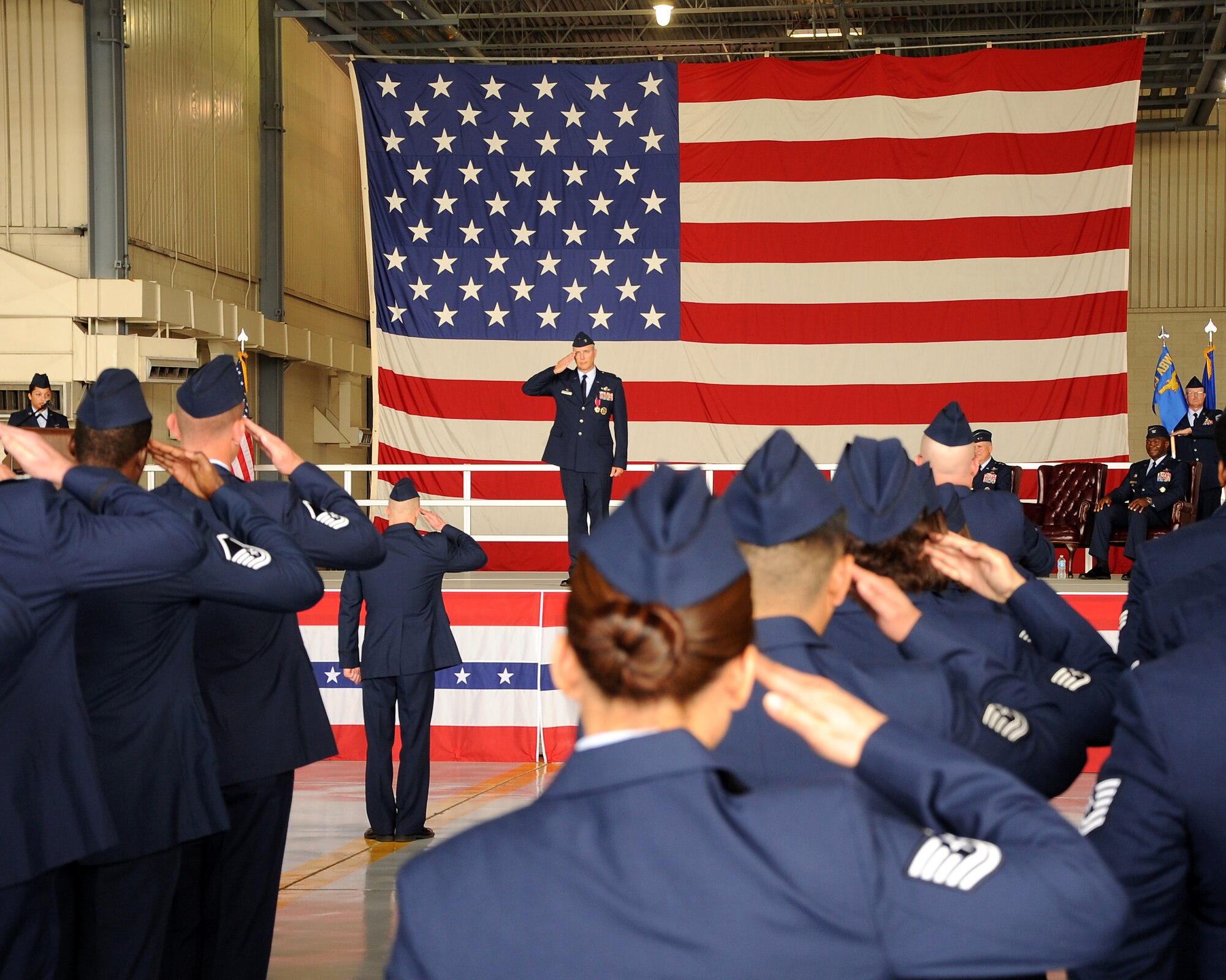 Service members at Grand Forks Air Force Base, N.D., render a final salute to the outgoing commander of the 319th Air Base Wing, Col. Paul Bauman, during a change of command ceremony on July 1, 2015. Col. Rodney Lewis assumed command after Bauman, who received the guidon two years ago. (U.S. Air Force Photo by Senior Airman Zachiah Roberson)