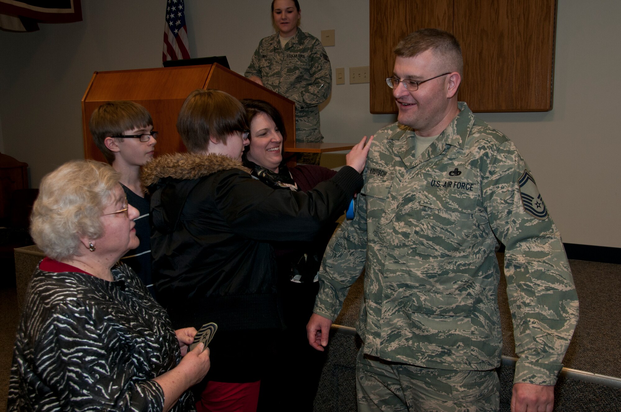 Members of the Krutsch family honor Chief Master Sgt. David A. Krutsch by presenting him with his new stripes during his promotion ceremony in Mansfield, OH, Mar. 7, 2015. Chief Master Sgt. is the highest enlisted grade in the United States Air Force. (U.S. Air National Guard Photo by Tech. Sgt. Joe Harwood\Released)