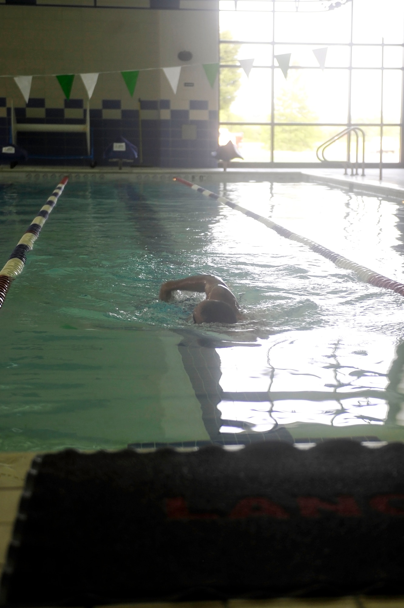 U.S. Air Force Maj. Elbert Mose, Air Combat Command Science and Technology Division deputy branch chief, swims in the Shellbank Fitness Center indoor pool at Langley Air Force Base, Va., July 1, 2015. In addition to an indoor pool, Shellbank also offers a basketball court, indoor and outdoor track, a weight room and sauna. (U.S. Air Force photo by Senior Airman Breonna Veal/Released)