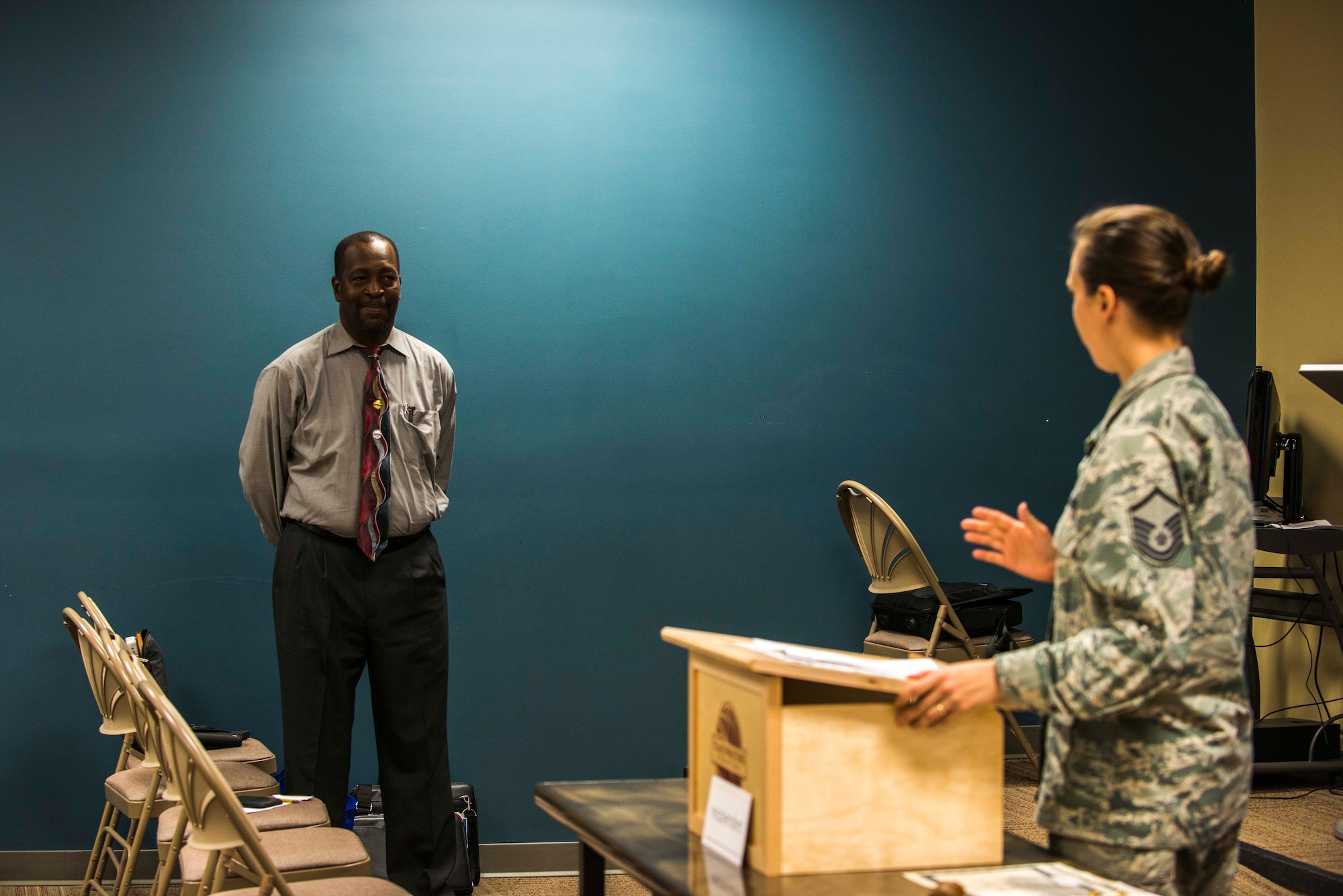 U.S. Air Force Master Sgt. Evita Bodhi, right, Moody Talking Tigers vice president of membership, speaks with Jerry Bullard, incoming MTT president, after his 15-minute speech during the 2015 MTT inauguration ceremony June 25, 2015, at Moody Air Force Base, Ga. Bodhi critiqued Bullard’s speech to improve his speech delivery. (U.S. Air Force photo by Airman 1st Class Dillian Bamman/Released)