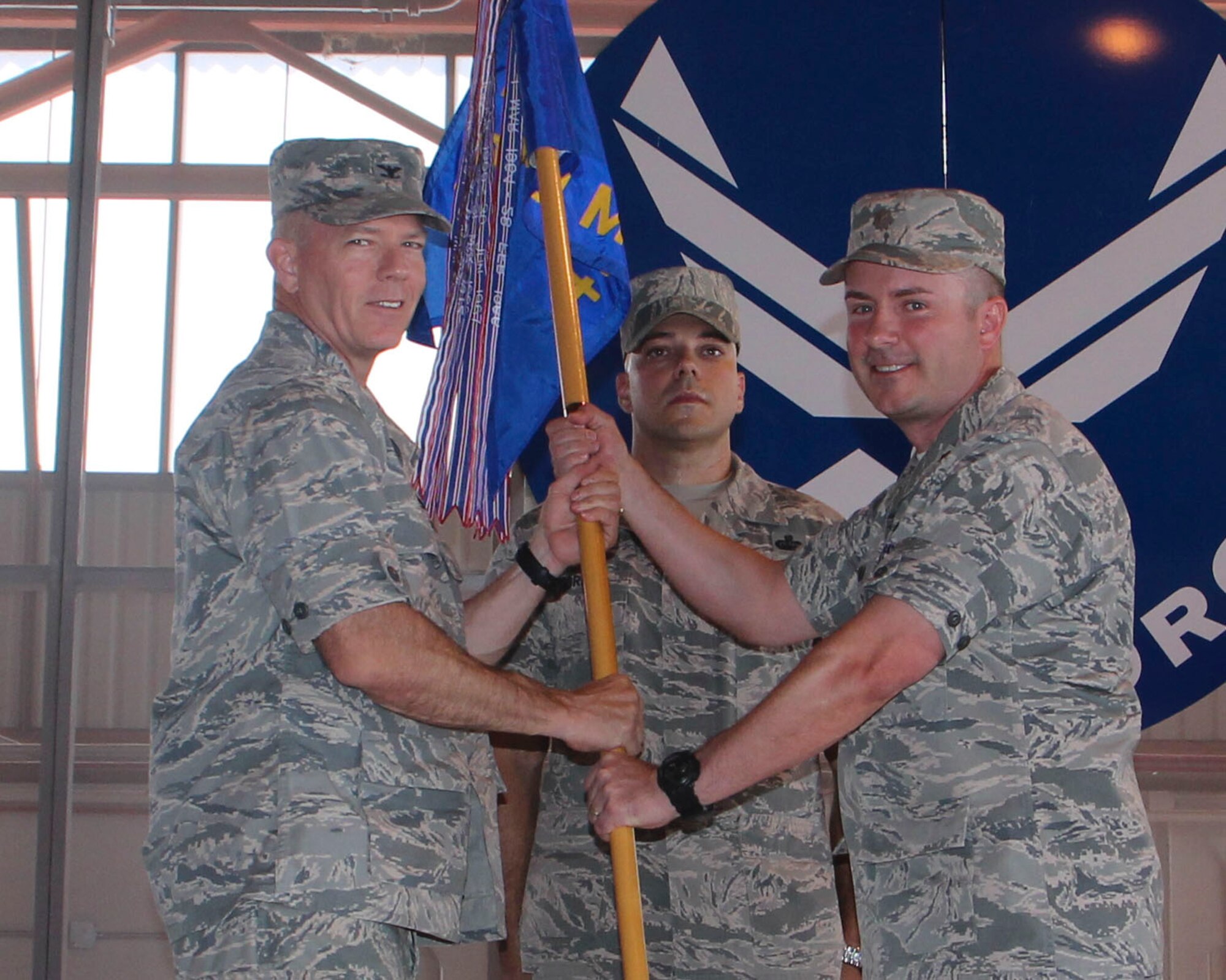 Major Anthony Vieira, 49th Maintenance Squadron outgoing commander, hands over the 49th MXS guidon to Col. Michael Shea, 49th Maintenance Group commander, during the 49th MXS Change of Command ceremony at Holloman Air Force Base, N.M., June 30, 2015. During the ceremony, Vieira relinquished command of the 49th MXS to Maj. Christopher Reese. (U.S. Air Force photo by Airman 1st Class Emily A. Kenney/Released)   