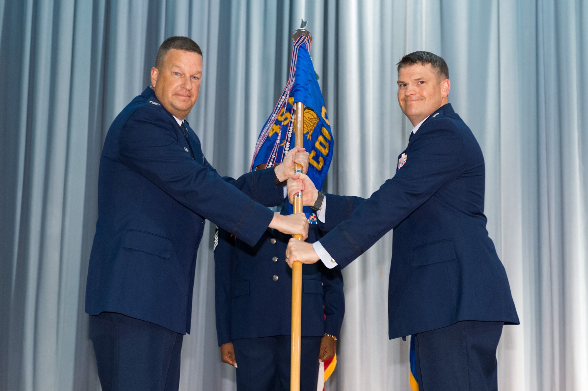 Col. Matthew Wallace, 45th Mission Support Group Wing commander, left, presents Col. Aaron Boyd, 45th Contracting Squadron commander, with the 45th CONS guidon during a change of command ceremony June 30, 2015, at Patrick Air Force Base, Fla. Changes of command are a military tradition representing the transfer of responsibilities from the presiding officials to the upcoming official. (U.S. Air Force photo/Cory Long) (Released)
