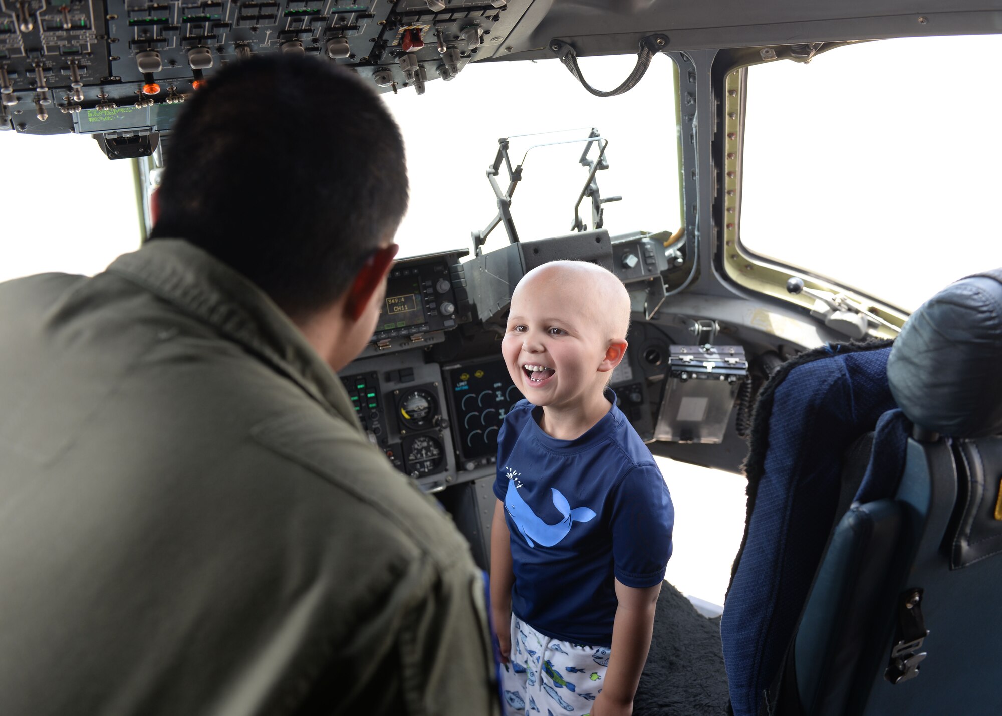 ALTUS AIR FORCE BASE, Okla. – Jaxon Dugger smiles at U.S. Air Force Capt. Rorey Faraon, a 58th Airlift Squadron C-17 Globemaster III cargo aircraft pilot, while getting a tour of the aircraft June 26,2015. Jaxon also toured the U.S. Air Force KC-135 Stratotanker refueler aircraft. (U.S. Air Force photo by Airman 1st Class Kirby Turbak/Released)
