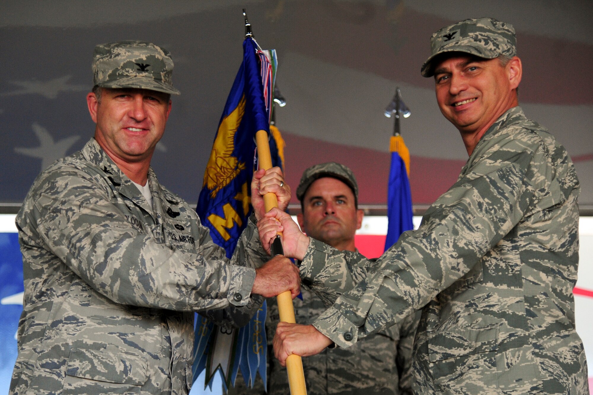 Col. Mark Slocum (left), 4th Fighter Wing commander, passes the guidon to Col. Shannon Cooper, incoming 4th Maintenance Group commander, during a change of command ceremony, June 29, 2015, at Seymour Johnson Air Force Base, North Carolina. Cooper previously served as the commander of the 380th Expeditionary Maintenance Group, Southwest Asia, before assuming command of the 4th MXG. (U.S. Air Force photo/Senior Airman Brittain Crolley)