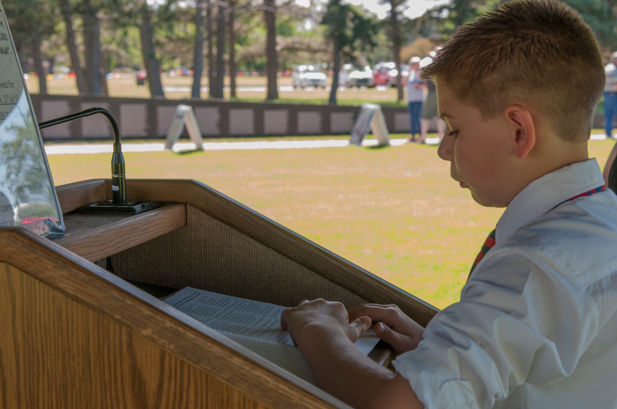 Gavin Riley, 11, son of Tech. Sgt. Sarah Donis, 90th Security Support Squadron Keys and Codes Control Center non-commissioned officer-in-charge, F.E. Warren Air Force Base, Wyo., reads names of Americans who died during the Vietnam War June 26, 2015, at the American Veterans Traveling Tribute hosted at Lions Park in Cheyenne, Wyo. Riley canceled his summer travel plans once he learned of the opportunity to volunteer at the AVTT because it was too important to miss, he said. (U.S. Air Force photo by Senior Airman Jason Wiese)