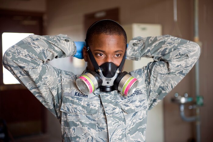 Senior Airman Stephen Kaham, 99th Civil Engineer Squadron pest management journeyman, dons a protective mask before spraying insecticides on Nellis Air Force Base, Nev., June 29, 2015. Pest management sprays insecticide inside and outside of buildings on base as needed. (U.S. Air Force photo by Airman 1st Class Rachel Loftis)