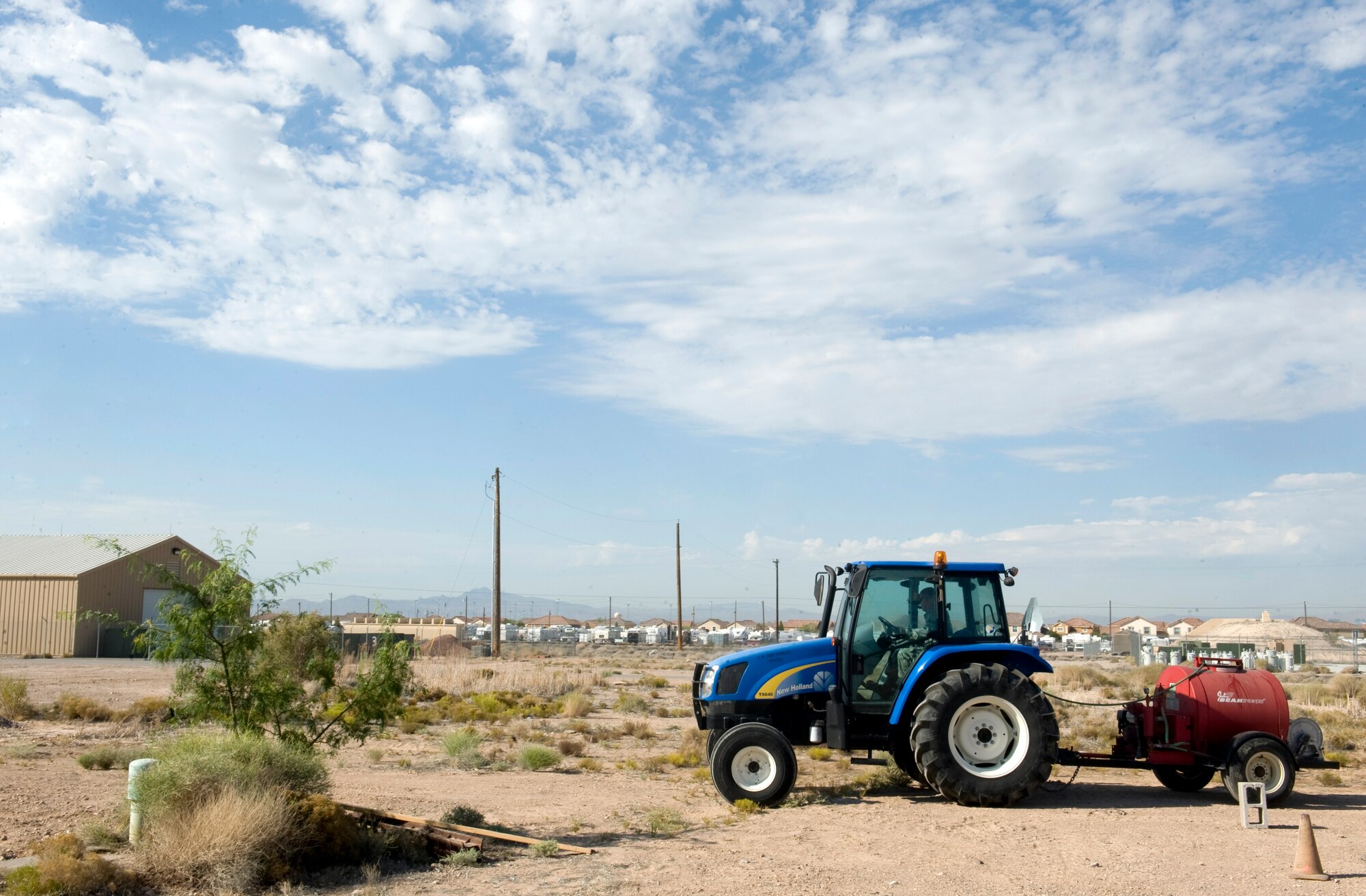 Senior Airman David Dion, 99th Civil Engineer Squadron pest management journeyman, sprays herbicides across Nellis Air Force Base, Nev., June 29, 2015. Pest management uses herbicides to kill unwated plant life such as weeds. (U.S. Air Force photo by Airman 1st Class Rachel Loftis) 