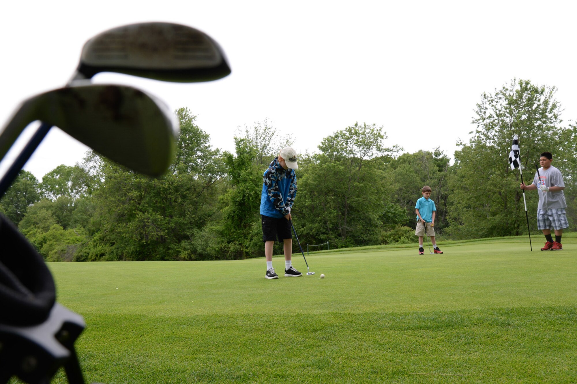 Matthew Guy, left, prepares to putt as Trevor Foreman, center, and Zack Pagnini stand nearby during a Golf 4 Kids program at the Patriot Golf Course in Bedford, Mass., June 26. The Golf 4 Kids program is an affordable and fun way to get junior golfers, ages 7-15, out on the links in small groups so they get a real feel for the game. They'll learn about the rules and etiquette of play, which clubs to use and how to take the game in stride. (U.S. Air Force photo by Linda LaBonte Britt)
