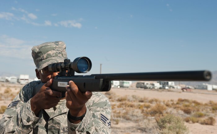 Senior Airman Reuben Moss, 99th Civil Engineer Squadron pest management journeyman, aims a pellet rifle at his target on Nellis Air Force Base, Nev., June 29, 2015. Pest management uses these rifles to control the bird population on the flightline. (U.S. Air Force photo by Airman 1st Class Mikaley Towle)