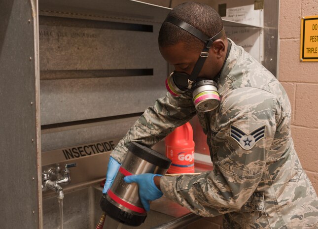 Senior Airman Stephen Kaham, 99th Civil Engineer Squadron pest management journeyman, rinses out an insecticide canister at the pest management shop on Nellis Air Force Base, Nev., June 29, 2015. Pest management sprays inside and outside of buildings to keep unwated pests away. (U.S. Air Force photo by Mikaley Towle)