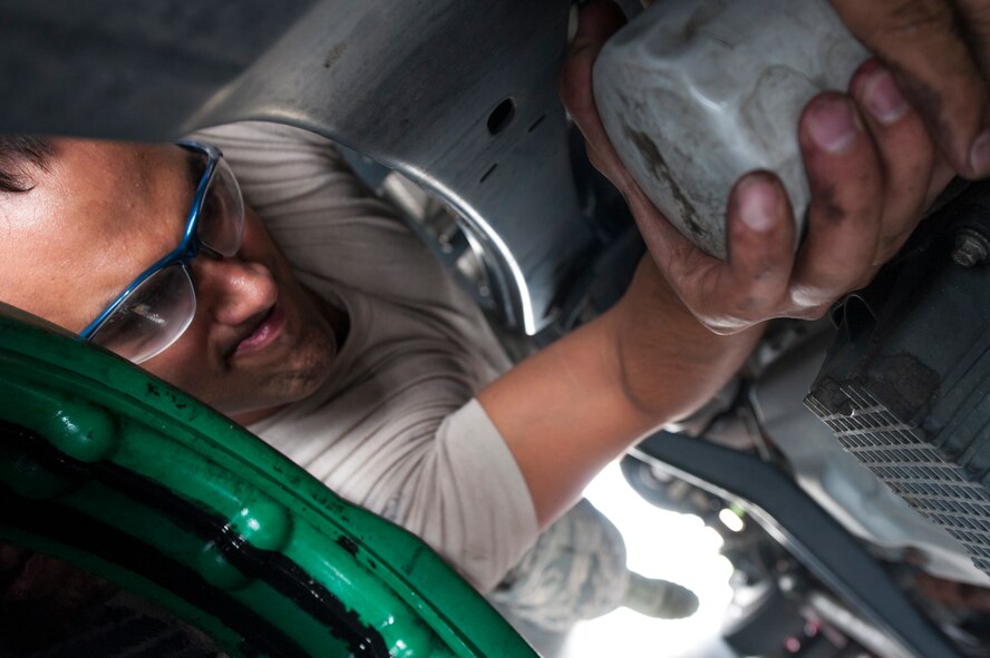 U.S. Air Force Airman 1st Class Nigell McAlpin, 23d Logistics Readiness Squadron special vehicle maintenance journeyman, replaces an oil filter in a fire truck June 30, 2015, at Moody Air Force Base, Ga. The 23d LRS Vehicle Management Flight specializes in maintaining special duty vehicles for base support. (U.S. Air Force photo by Airman 1st Class Dillian Bamman/Released)