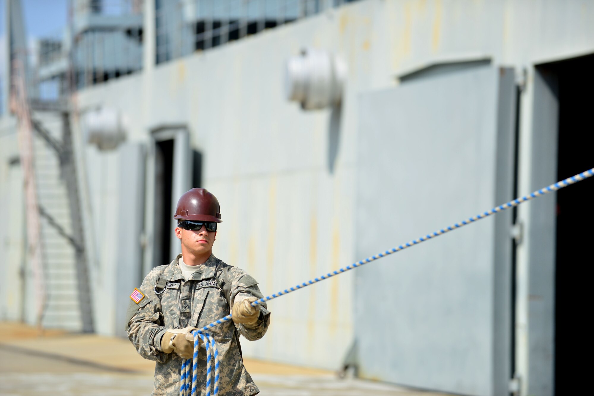U.S. Army Pvt. Xavier Guitierrez, Transportation School cargo specialist course student, hoists a transport case during a cargo training exercise at Fort Eustis, Va. , June 25, 2015.During the exercise, students learned to work as a team to lift the cargo case on and off a training vessel. (U.S. Air Force photo by Staff Sgt. Natasha Stannard/Released)
