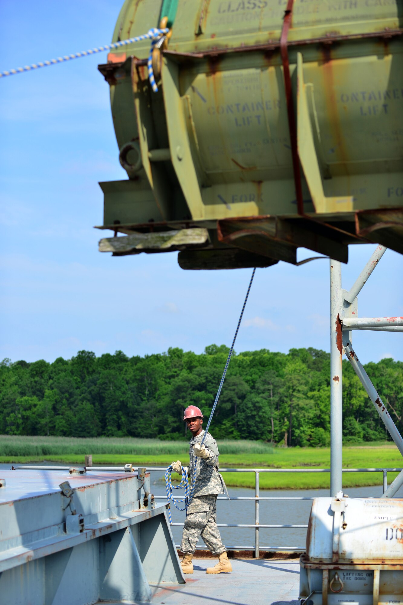 U.S. Army Pvt. Troy McMullen, Transportation School cargo specialist course student, hoists a transport case at Fort Eustis, Va., June 25, 2015. During this training, students learn foundational port terminal operations. (U.S. Air Force photo by Staff Sgt. Natasha Stannard/Released)