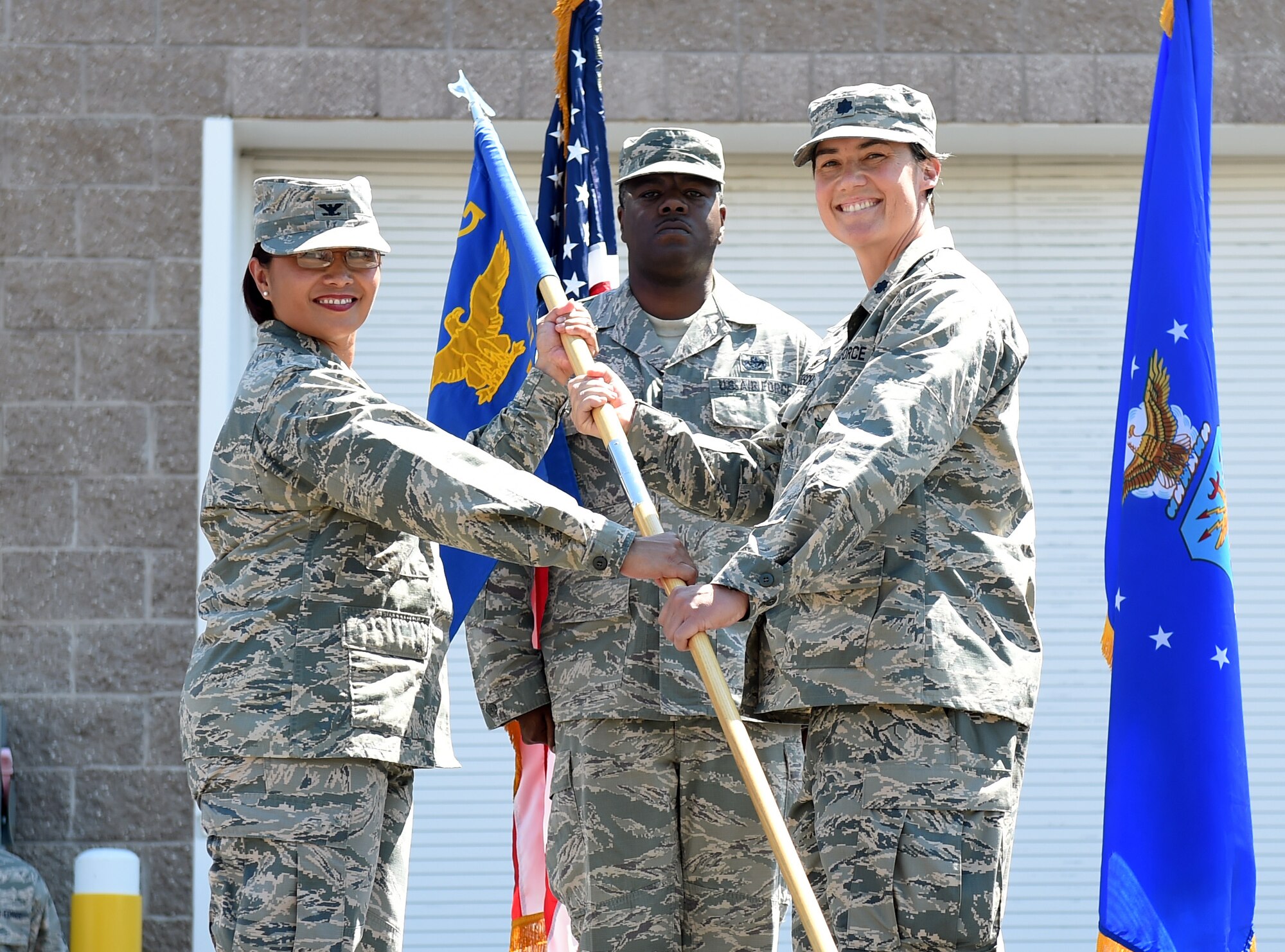 Col. Rose Jourdan, 460th Mission Support Group commander, left; presents the 460th Space Wing guidon to Lt. Col. Cynthia Clefisch, right; symbolizing her assumption of command as the 460th Civil Engineer Squadron commander June 30, 2015, on Buckley Air Force Base, Colo. Clefisch became the commander of the 460th CES after one year of service as the 380th Expeditionary CES, Southwest Asia commander. (U.S. Air Force photo by Airman 1st Class Emily E. Amyotte/Released)