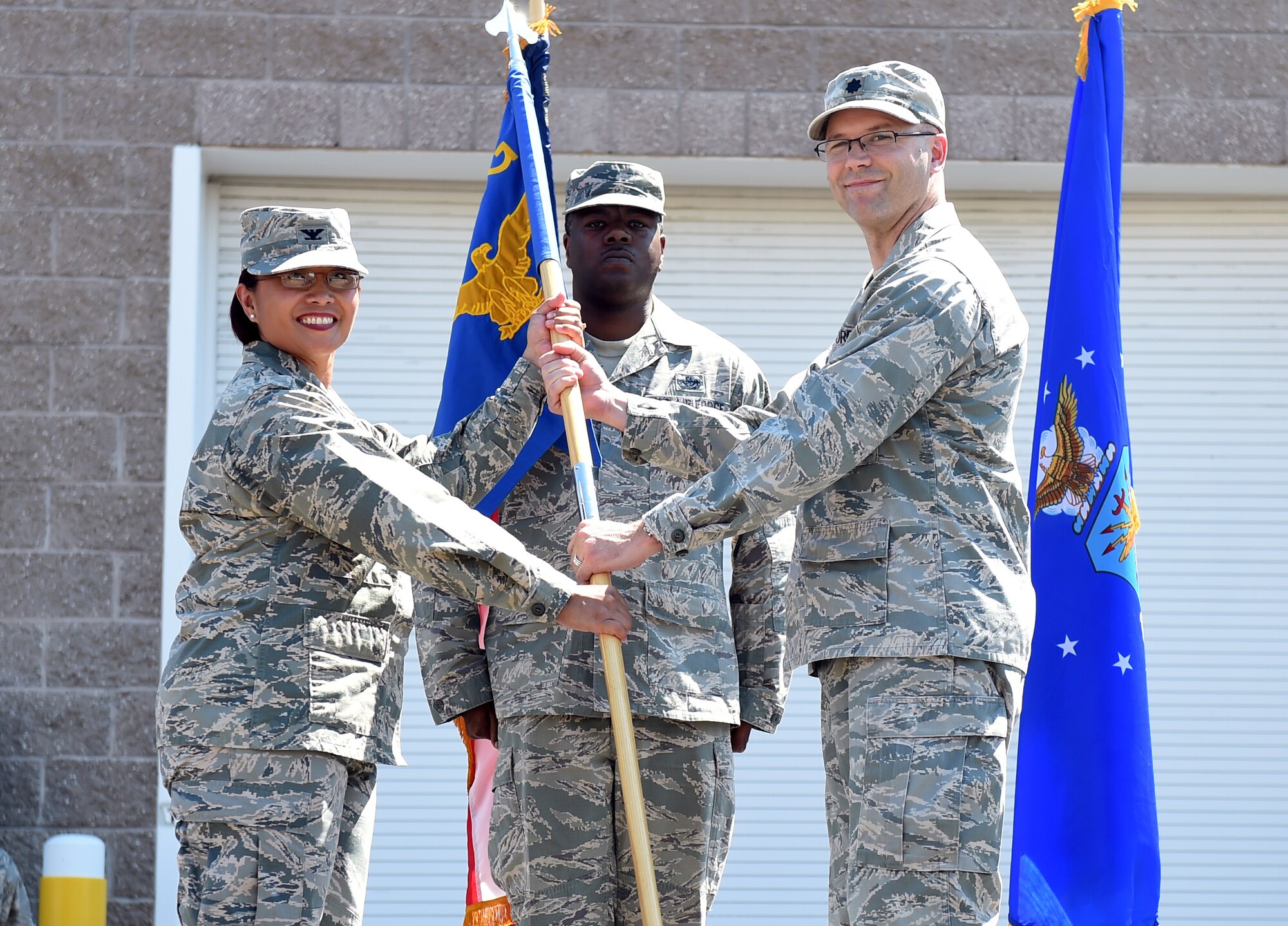 Lt. Col. Allen Theibeux, right; relinquishes his command of the 460th Civil Engineer Squadron to Col. Rose Jourdan, 460th Mission Support Group commander, left; during the change of command ceremony June 30, 2015, on Buckley Air Force Base, Colo. Theibeux has been in command of the 460th CES since June 2013, where he led the squadron through fiscal challenges, damaging weather events and decreases in manpower. (U.S. Air Force photo by Airman 1st Class Emily E. Amyotte/Released)