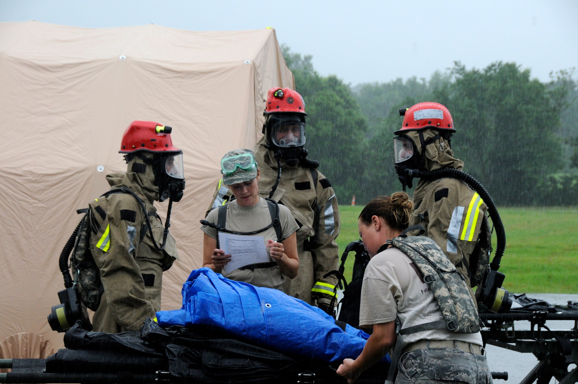 Members from the 182nd Airlift Wing's Fatality Search and Recovery Team (FSRT) review their checklist as they load a litter carrier with equipment before entering a "hot zone" during a CERFP exercise at the Boone County Fire District Training Center near Columbia, Mo., June 17, 2015 (U.S. Air National Guard photo by Tech. Sgt. Todd Pendleton)(Released)   