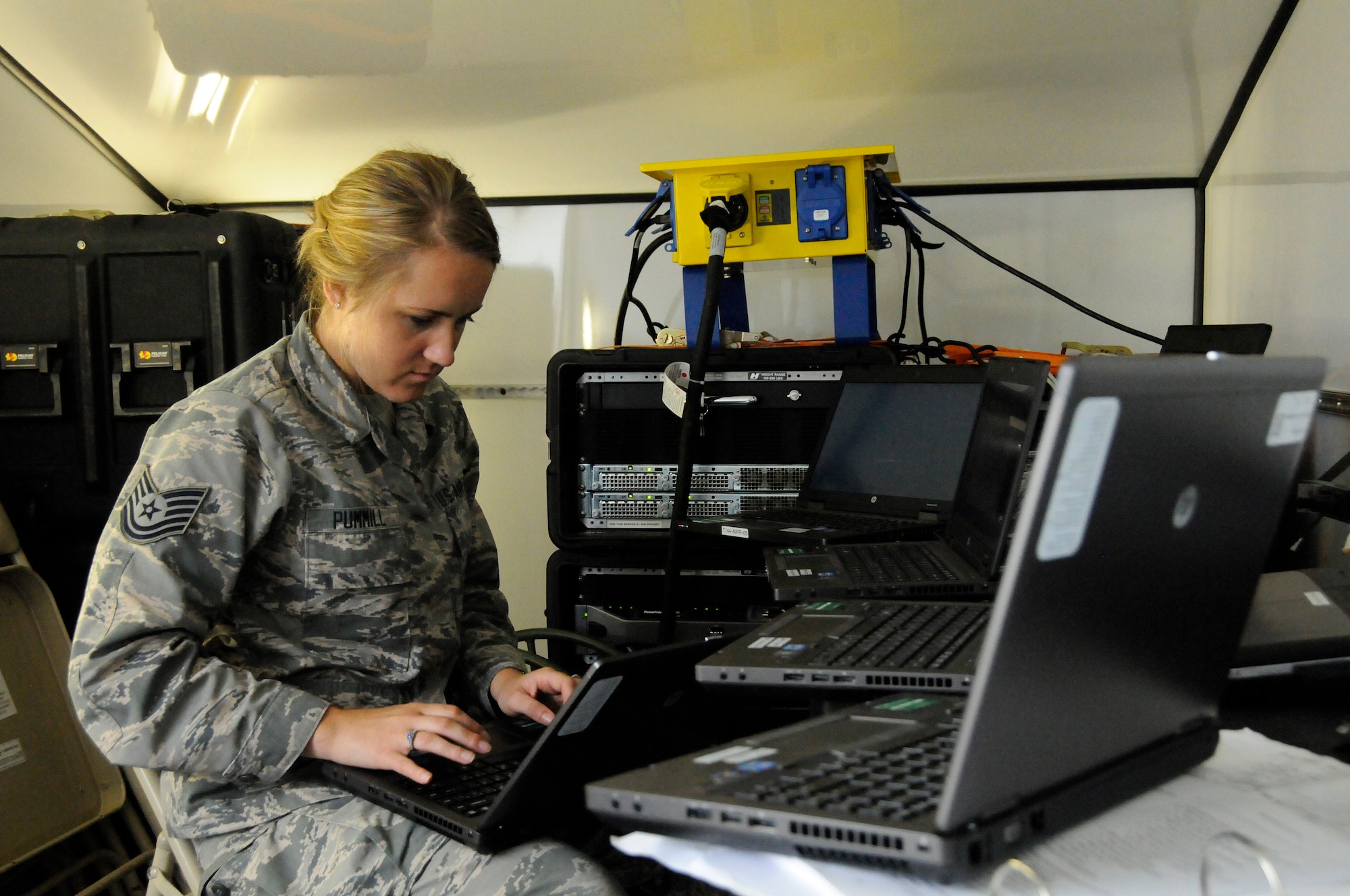 Tech. Sgt. Candace Pummill, a cyber systems operations specialist with the 264th Combat Communications Squadron, Peoria, Ill., configures a laptop computer for use inside the Joint Incident Site Communications Capability (JISCC) trailer June 16, 2015, at the Boone County Fire District Training Center near Columbia, Mo. (U.S. Air National Guard photo by Tech. Sgt. Todd Pendleton)(Released)