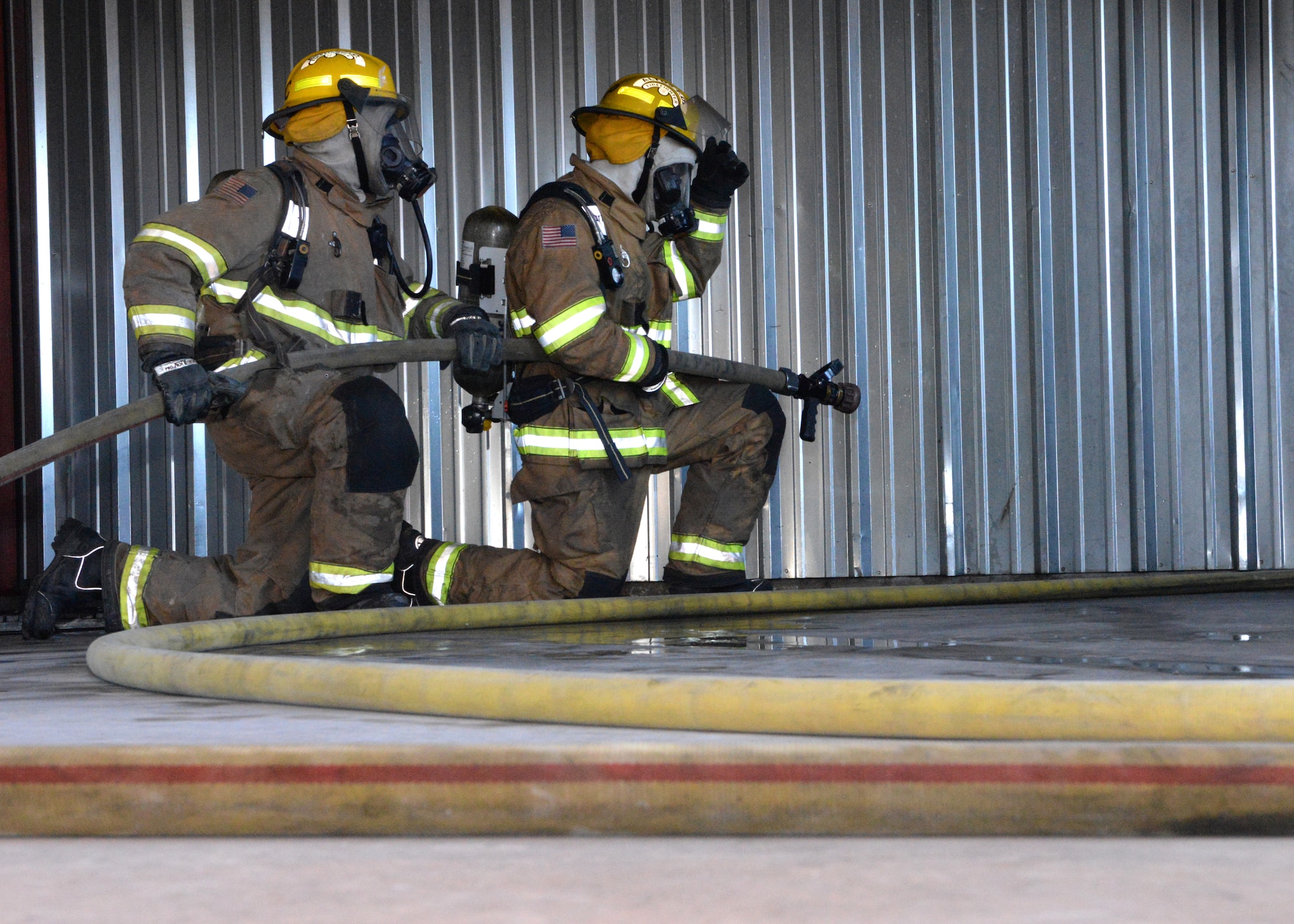 ALTUS AIR FORCE BASE, Okla. – Firefighters from the City of Altus wait outside a structural live fire training room during training, June 24, 2015. During this training, roughly 30 firefighters from Altus and Frederick received structural live fire training, forcible entry door training and confined space entry maze training. (U.S. Air Force photo by Airman 1st Class Megan E. Acs/Released)