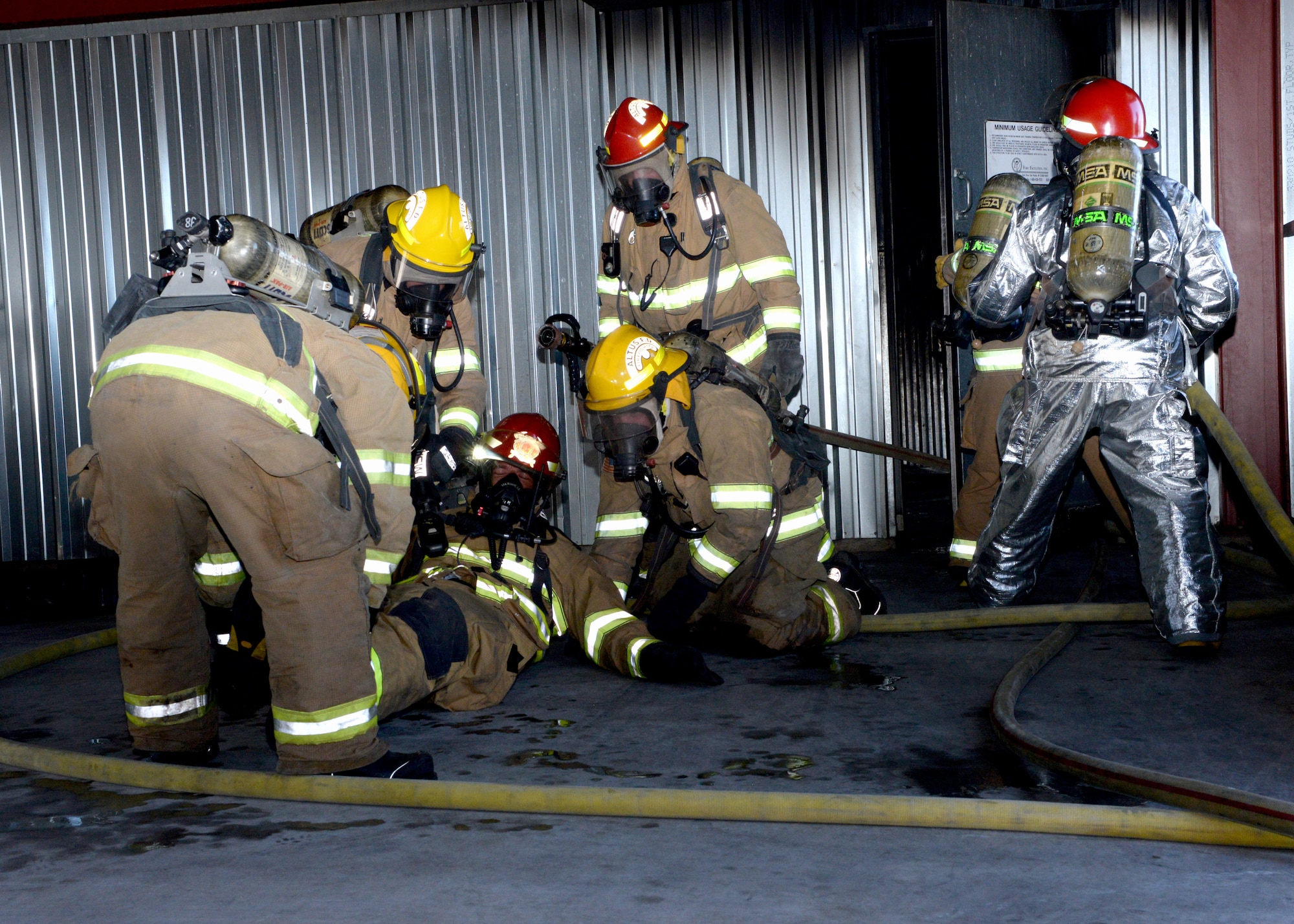 ALTUS AIR FORCE BASE, Okla. – Firefighters from the City of Altus drag a teammate out from a structural live fire trainer during a mayday exercise, June 24, 2015. A mayday situation is when a firefighter becomes incapacitated and has to be removed from the building. (U.S. Air Force photo by Airman 1st Class Megan E. Acs/Released)