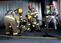 ALTUS AIR FORCE BASE, Okla. – Firefighters from the City of Altus drag a teammate out from a structural live fire trainer during a mayday exercise, June 24, 2015. A mayday situation is when a firefighter becomes incapacitated and has to be removed from the building. (U.S. Air Force photo by Airman 1st Class Megan E. Acs/Released)