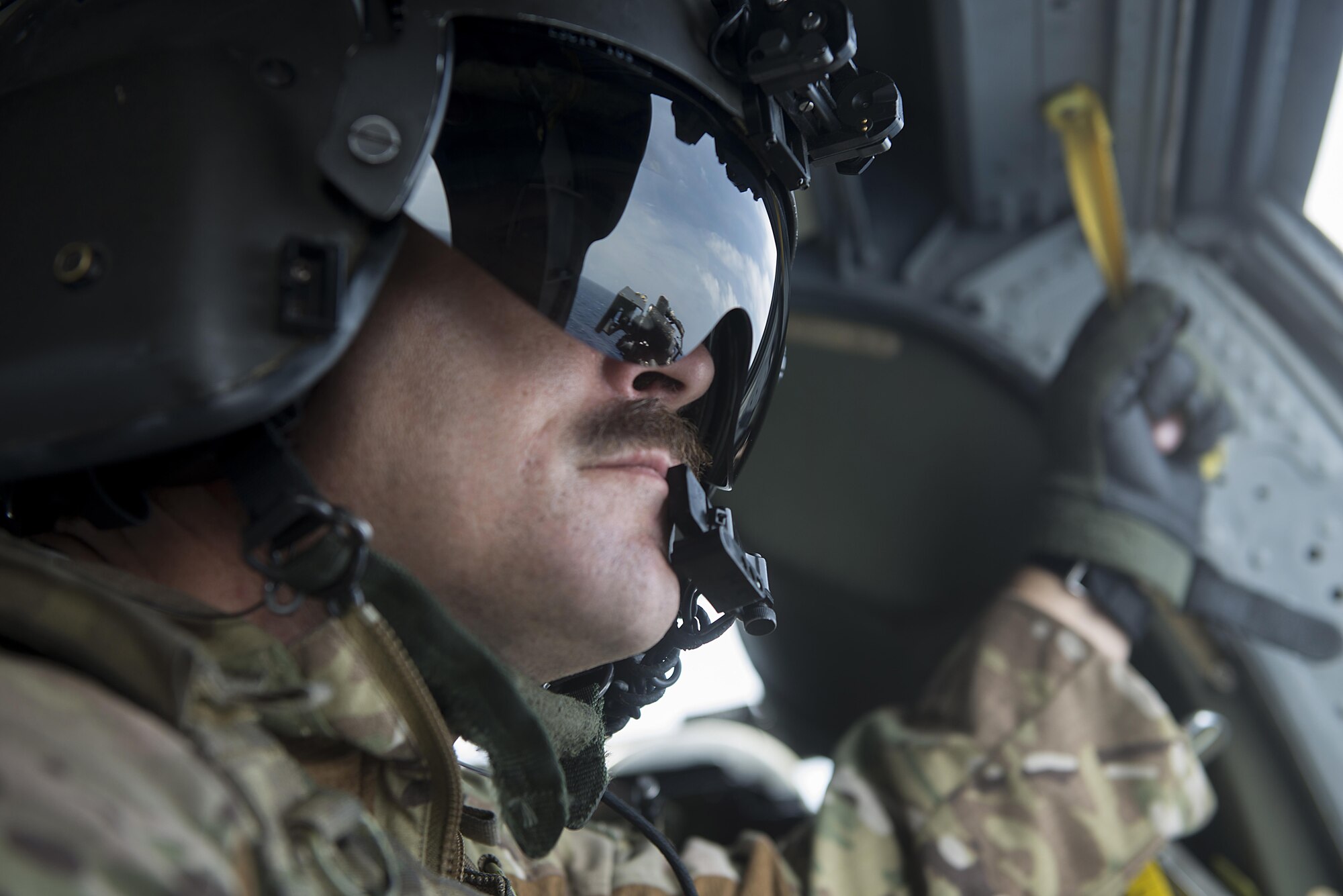 U.S. Air Force Master Sgt. Kenton Lewis, 33rd Rescue Squadron special missions aviator, looks out a window of a 33rd RQS HH-60G Pave Hawk helicopter during a large force exercise near Okinawa, Japan, June 30, 2015. During the exercise, numerous U.S. Air Force flying squadrons from Kadena Air Base, Japan, partnered with Vermont Air National Guard F-16 Fighting Falcons and U.S. Marine Corps units from Marine Corps Air Station on Okinawa in order to improve interservice interoperability in the region. (U.S. Air Force photo by Staff Sgt. Maeson L. Elleman)