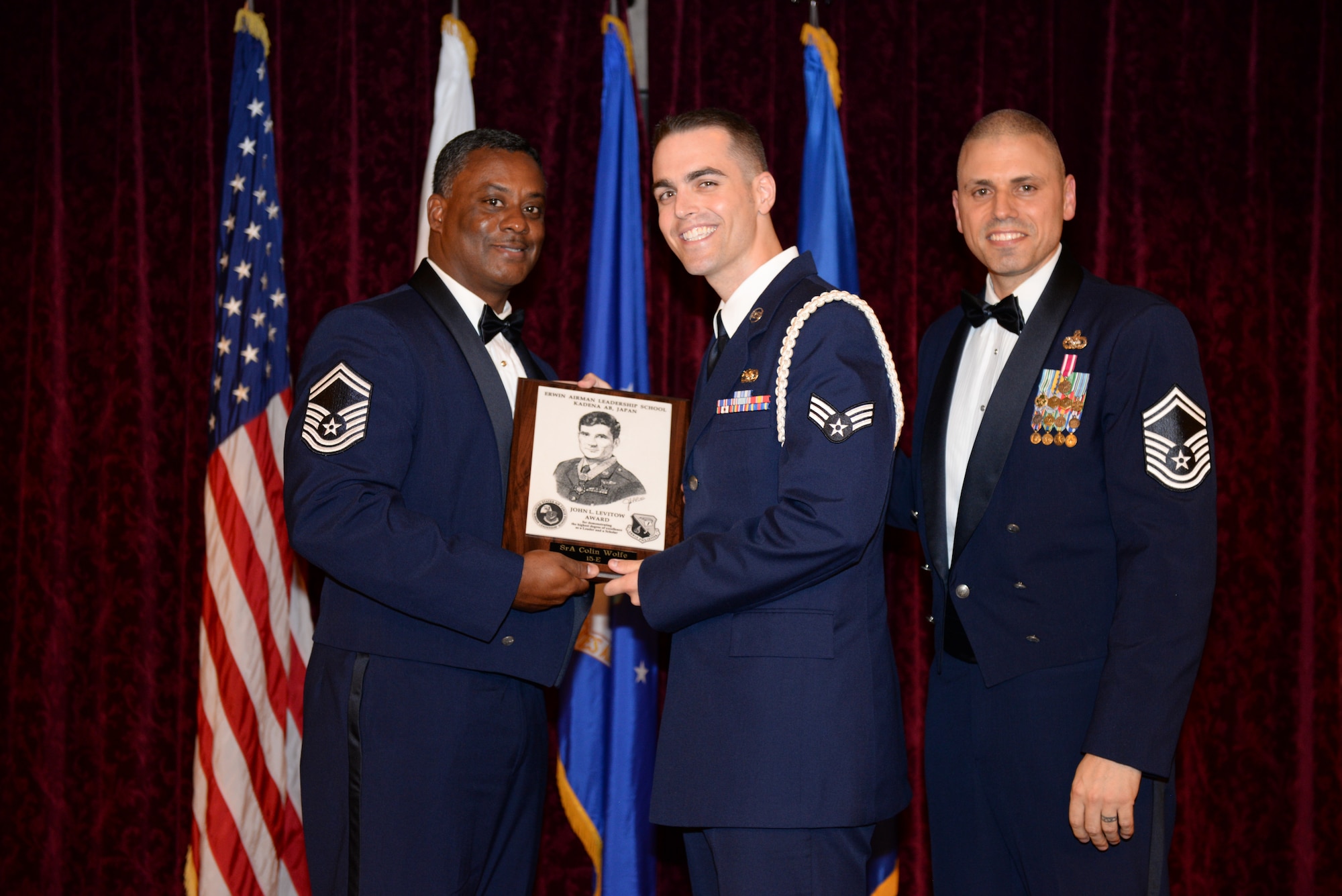 U.S. Air Force Senior Airman Colin Wolfe, 18th Maintenance Group Air Force Repair Enhancement Program liaison, receives the John L. Levitow Award during the Airman Leadership School Class 15-E graduation ceremony on Kadena Air Base, Japan, June 30, 2015. This award is presented to the student who earns the highest average score on evaluations and most embodies the Air Force core values. (U.S. Air Force photo by Senior Airman Omari Bernard)