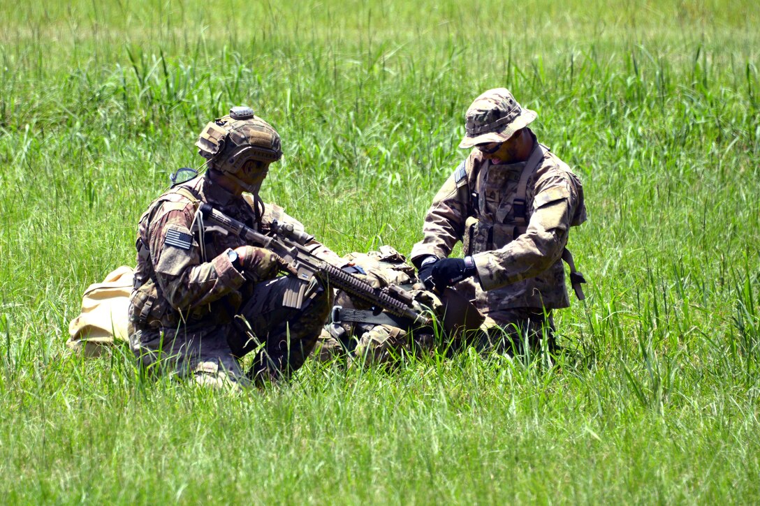 Army Rangers gather their parachutes and gear after conducting military free-fall operations to kick off the 2015 Ranger Rendezvous at Fryar Drop Zone on Fort Benning, Ga., June 22, 2015.