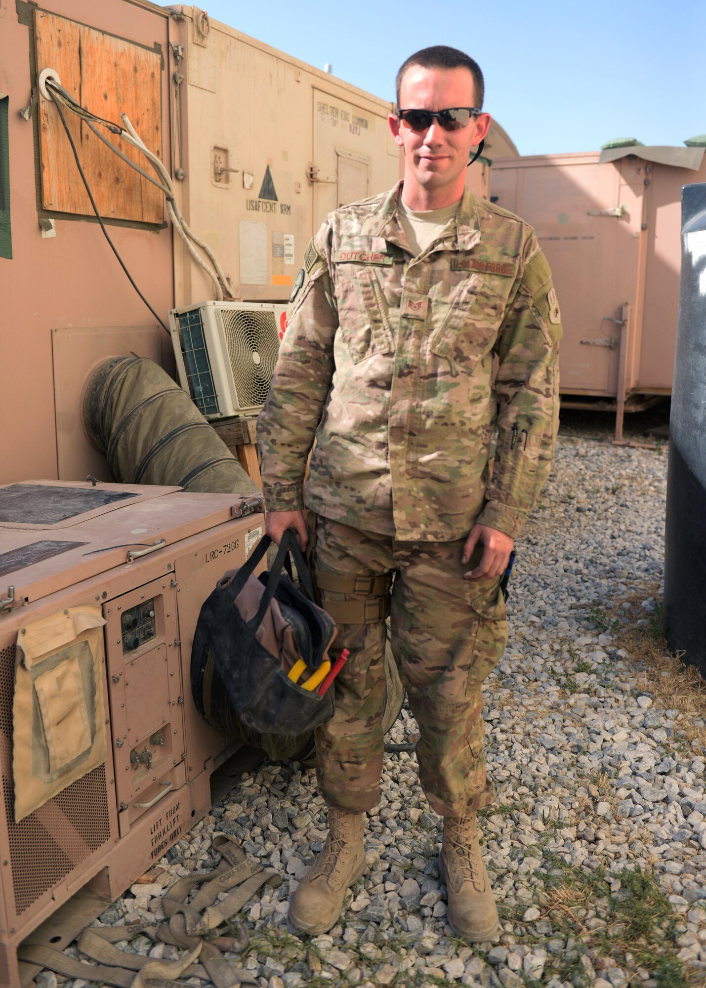 U.S. Air Force Staff Sgt. Russell Dutcher, 455th Expeditionary Civil Engineer Squadron, HVAC technician, poses for a photo after completing a work order June 30, 2015, at Bagram Airfield, Afghanistan. Dutcher who is part of the 1000s of Hands Project, is responsible for responding to all work orders dealing with AC problems as well as keeping Bagram’s mission equipment such as computers and servers cool. (U.S. Air Force photo by Senior Airman Cierra Presentado/Released)