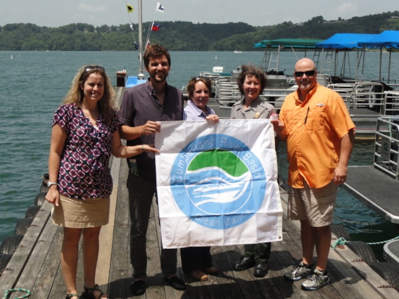 U.S. Army Corps of Engineers Nashville District officials present a "Clean Marina" flag to Sunset Marina at Dale Hollow Lake in Monroe, Tenn., June 22, 2015.  They celebrated the marina's recertification in the Cumberland River Basin Clean Marina Partnership, a commitment to pollution prevention and water resource protection. In the photo are (Left to Right) Crystal Tingle, Nashville District; Jed Grubbs, Cumberland River Compact; Betsy Woods, Tennessee Wildlife Resources Agency; Park Ranger Sondra Carmen, Dale Hollow Lake; and Tom Allen, Sunset Marina.