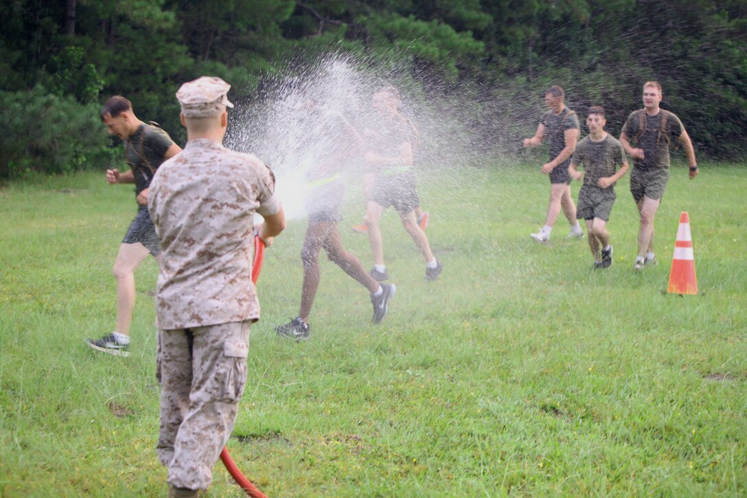Marines with Marine Wing Support Squadron 274 get cooled off with water from a hose after their inaugural Ironman Challenge at Marine Corps Air Station Cherry Point, N.C., on July 2, 2015. The Inaugural Ironman Challenge was comprised of a one-mile sandbag carry and wall and log negotiation. The event tested Marines’ mental and physical endurance while building camaraderie within the squadron.
