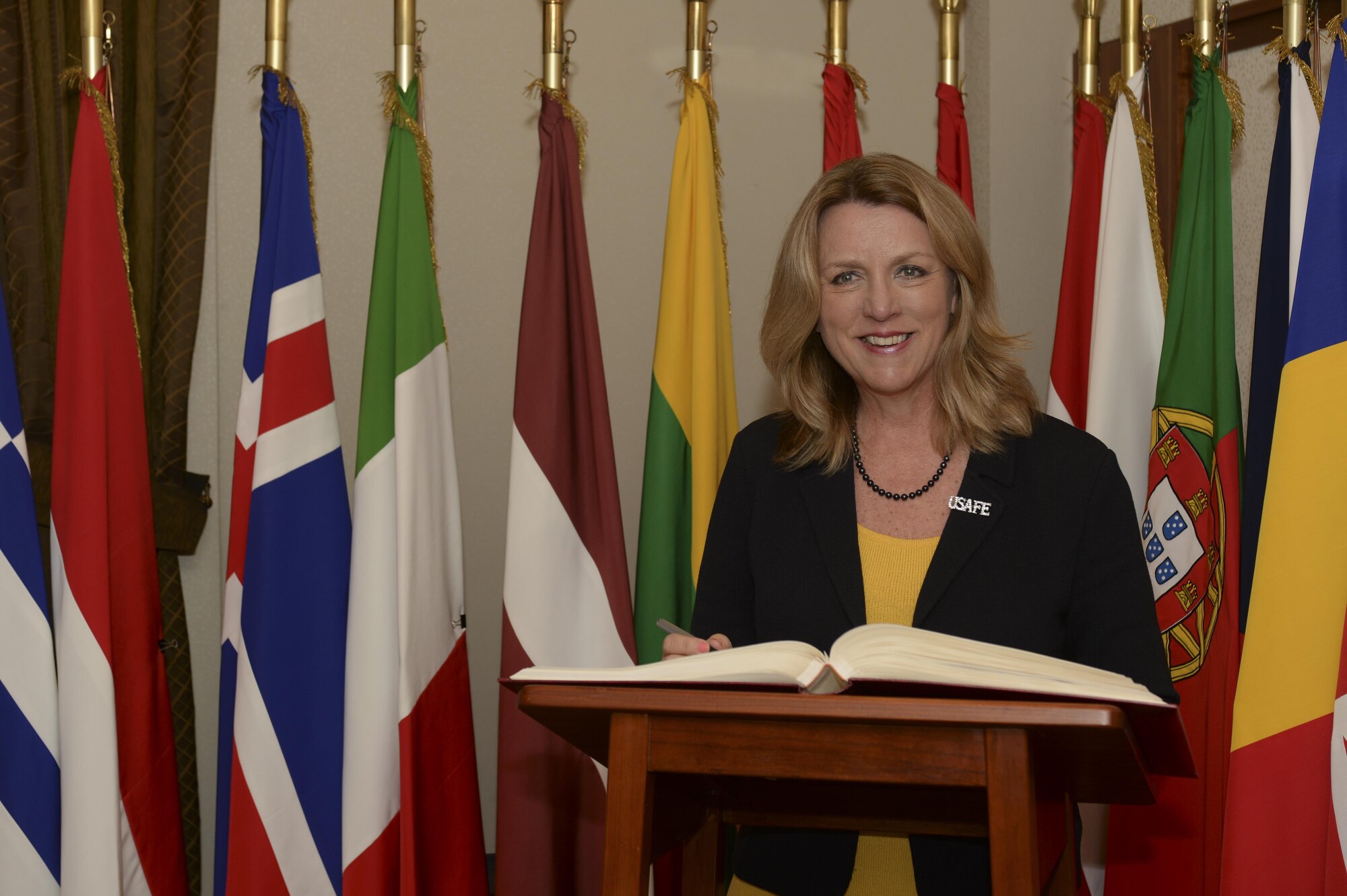 Secretary of the Air Force Deborah Lee James smiles as she signs a visitor book in the office of the commander of Supreme Allied Command, Europe, during her visit to Supreme Headquarters Allied Powers Europe at Mons, Belgium, June 23, 2015. The secretary completed a visit of installations through Europe June 24, 2015, to meet Airmen, community leaders and allied and partner nation defense chiefs. (U.S. Air Force photo/Staff Sgt. Joe W. McFadden)