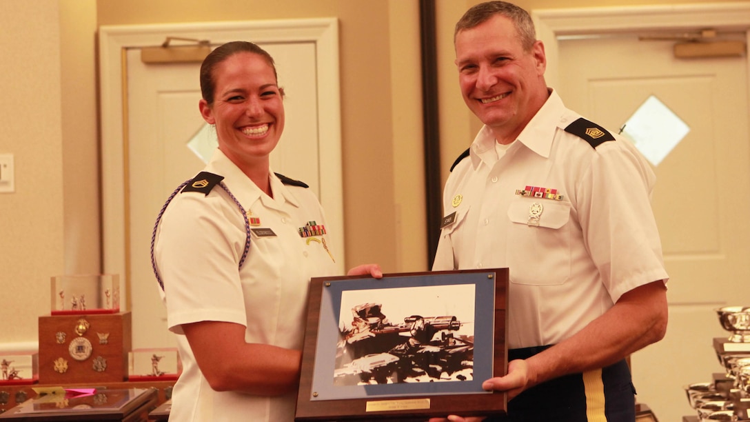 Army Staff Sgt. Amanda Elsenboss (left) receives an award from Army 1st. sgt. Sheldon Jones (left) during the award ceremony for the 54th Interservice Rifle Championship at Marine Corps Base Quantico, Virginia, July 1, 2015. Elsenboss placed in second in the Interservice Individual Long Range Championship Match Division B Match Rifle with a score of 398. Jones is the U.S. Army Marksmanship Team First Sergeant.