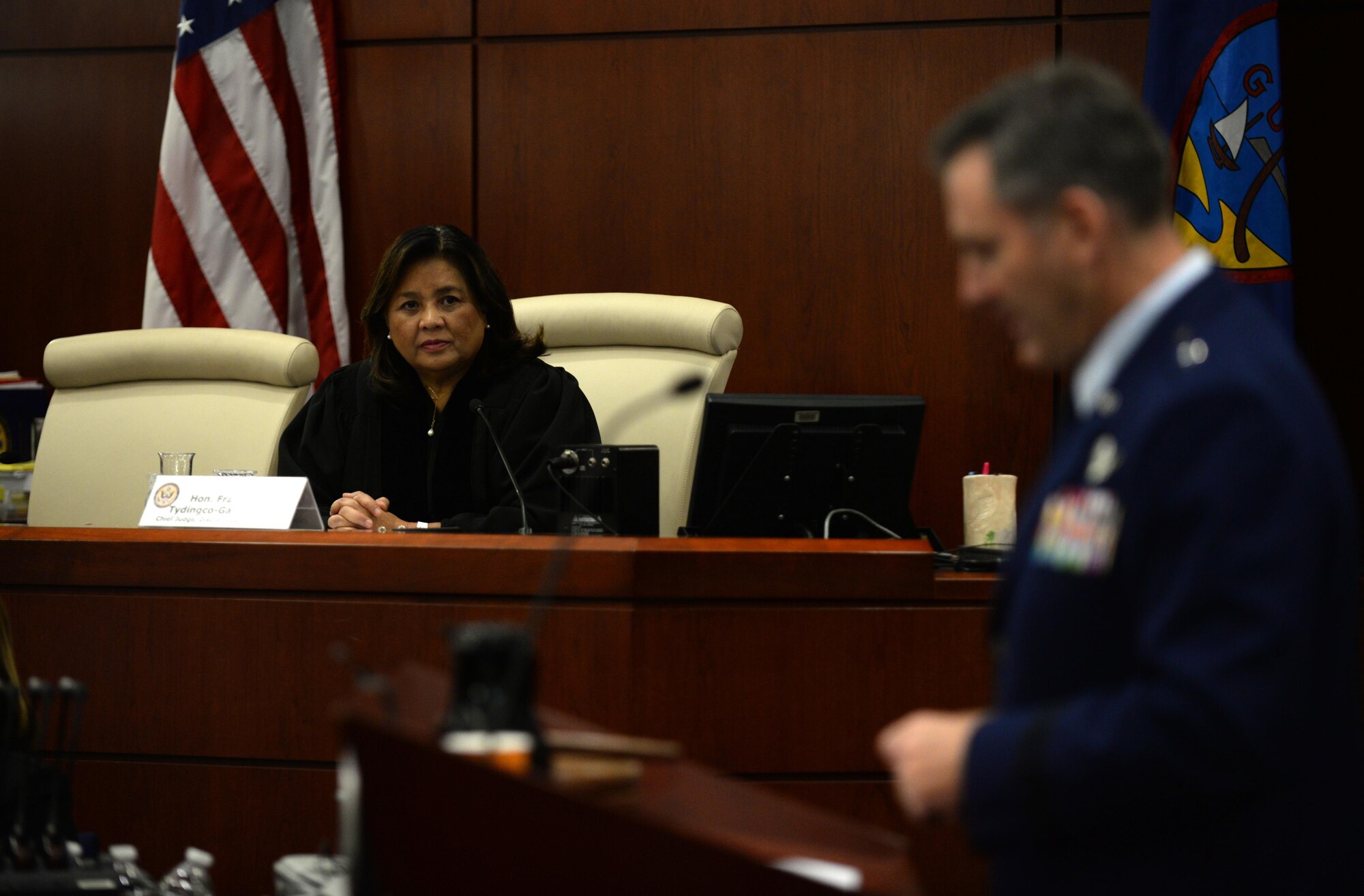 Frances Marie Tydingco-Gatewood, chief judge District Court of Guam, listens as Brig. Gen. Andrew Toth, 36th Wing commander, addresses newly naturalized U.S. citizens July 2, 2015, in Hagåtña, Guam. Twenty-four immigrants, originally from the Federated States of Micronesia, the Philippines, South Korea, Taiwan, Thailand and Vietnam, received their U.S. citizenship. (U.S. Air Force photo by Senior Airman Alexander W. Riedel/Released)
