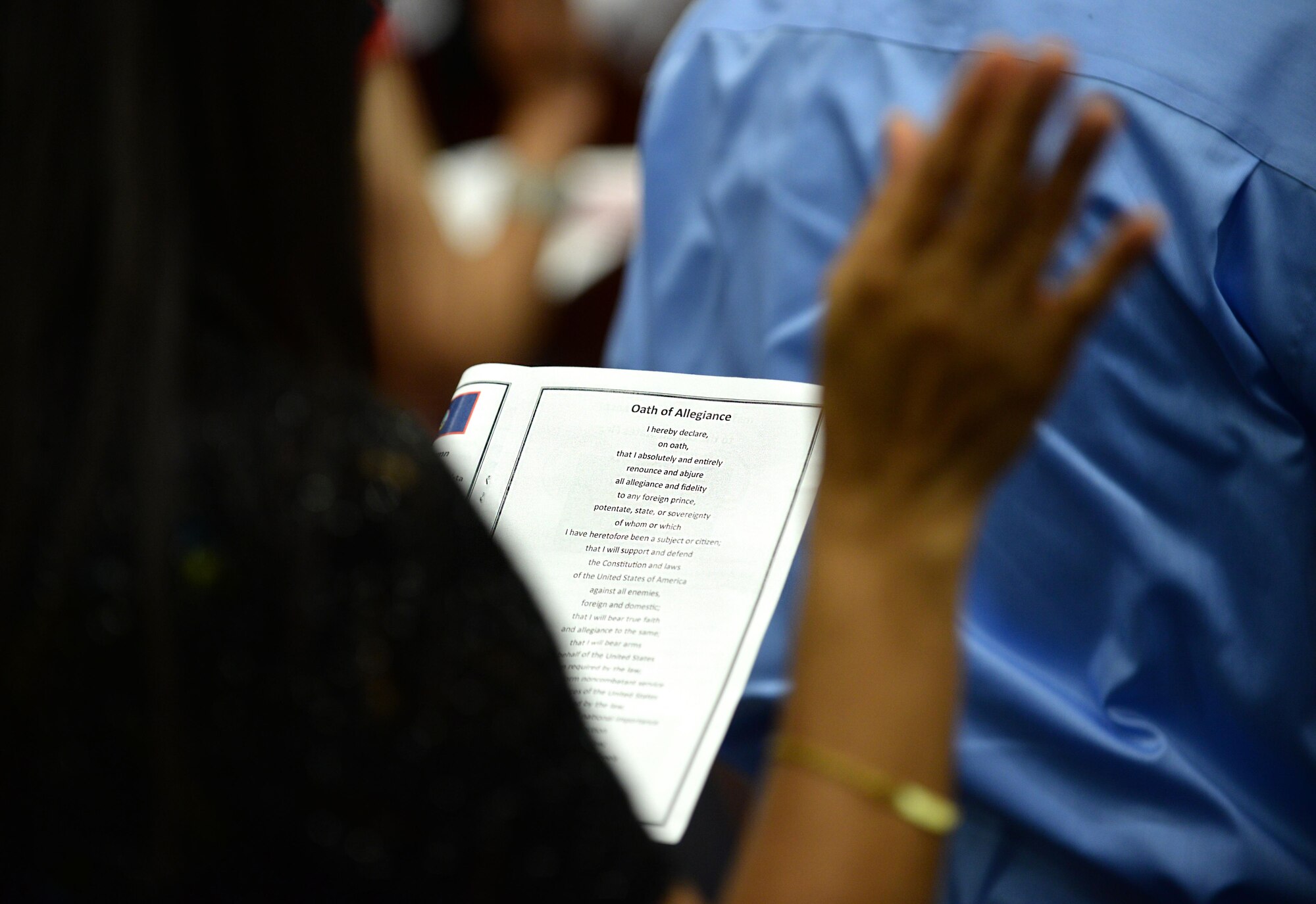 A new U.S. citizen reads the Oath of Allegiance July 2, 2015, in Hagåtña, Guam. Twenty-four applicants received their U.S citizenship during a naturalization ceremony held in conjunction with Independence Day weekend. (U.S. Air Force photo by Senior Airman Alexander W. Riedel/Released)