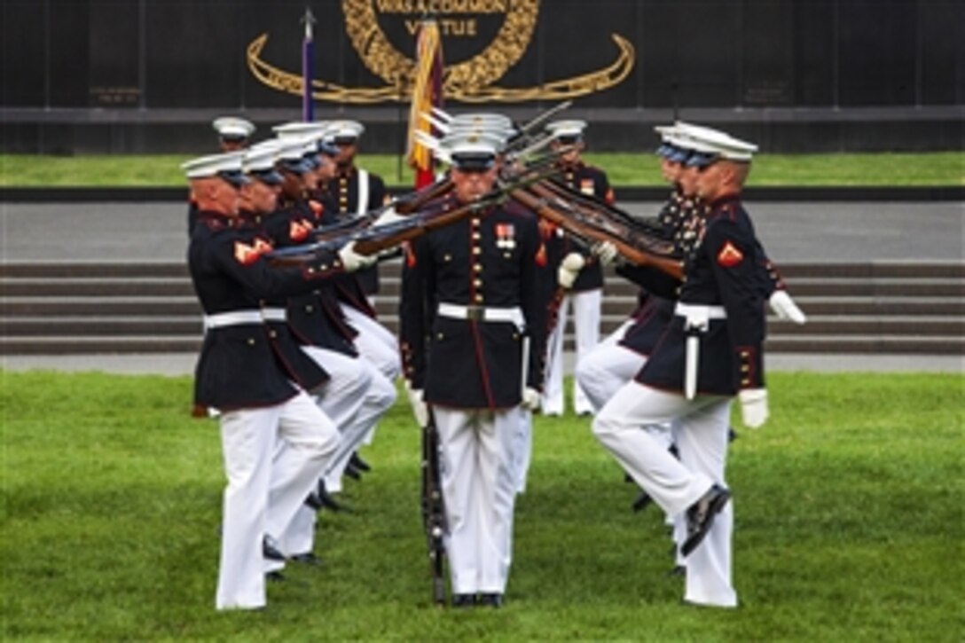 The U.S. Marine Corps Silent Drill Platoon preforms during a sunset parade at the U.S. Marine Corps War Memorial in Arlington, Va., June 30, 2015. Defense Secretary Ash Carter was the guest of honor.