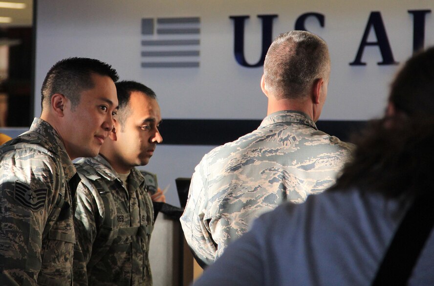 From left, Tech. Sgt. Peter Ahn, Tech Sgt. Alexis Flores and Master Sgt. Chris Pierce, all members of the 446th Security Forces Squadron, process through a ticketing counter at Seattle-Tacoma International Airport July 1. All three 446th SFS personnel left Washington as part of a mass deployment across Southwest Asia in support of the Global War on Terrorism. By the Fourth of July, more than 40 personnel from the squadron will be deployed. (Courtesy photo by Kevin Iriarte)