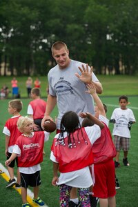 Rob Gronkowski, New England Patriots tight end, high-fives his team during a football camp on Joint Base Andrews, Md., July 2, 2015. Gronkowski, a three time Pro Bowler and Super Bowl XLIX champion, coached approximately 100 military children during the two-day camp. (U.S. Air Force photo/Tech. Sgt. Robert Cloys)