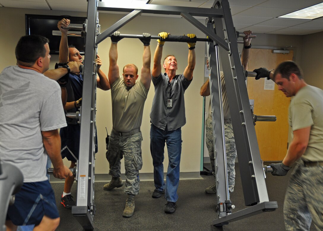 919th Special Operations Wing Airmen raise a squat rack in the Duke Field fitness center June 12 at Duke Field, Fla.   Dozens of Duke volunteers turned out to assist with the complete reconfiguration of the fitness center's equipment, all aimed at enhancing safety and traffic flow for guests. (U.S. Air Force photo/Dan Neely)