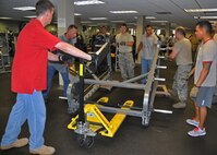 919th Special Operations Wing Airmen move a squat rack in the Duke Field fitness center June 12 at Duke Field, Fla.   Dozens of Duke volunteers turned out to assist with the complete reconfiguration of the fitness center's equipment, all aimed at enhancing safety and traffic flow for guests. (U.S. Air Force photo/Dan Neely)