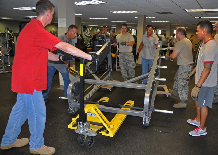 919th Special Operations Wing Airmen move a squat rack in the Duke Field fitness center June 12 at Duke Field, Fla.   Dozens of Duke volunteers turned out to assist with the complete reconfiguration of the fitness center's equipment, all aimed at enhancing safety and traffic flow for guests. (U.S. Air Force photo/Dan Neely)