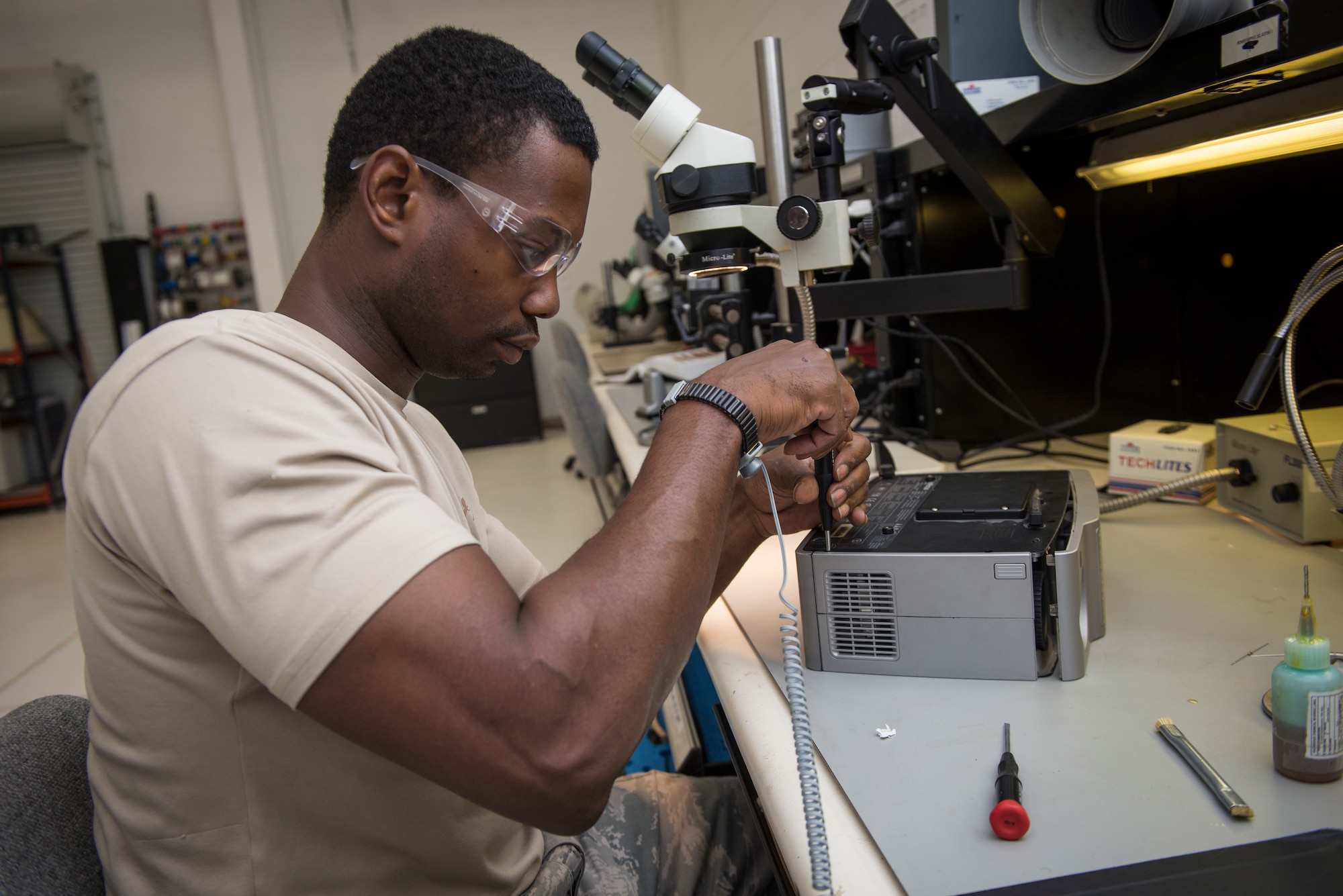 Staff Sgt. Mark Hawkins, Air Force Repair Enhancement Program lead technician, repairs a malfunctioning projector to avoid the Air Force having to spend the money on a replacement at Holloman Air Force Base, N.M., July 1, 2015. AFREP is there to save and avoid the wing costly money from equipment that’s either too difficult or expensive to repair and having a contractor come out to repair it. (U.S. Air Force photo by Senior Airman / Released)